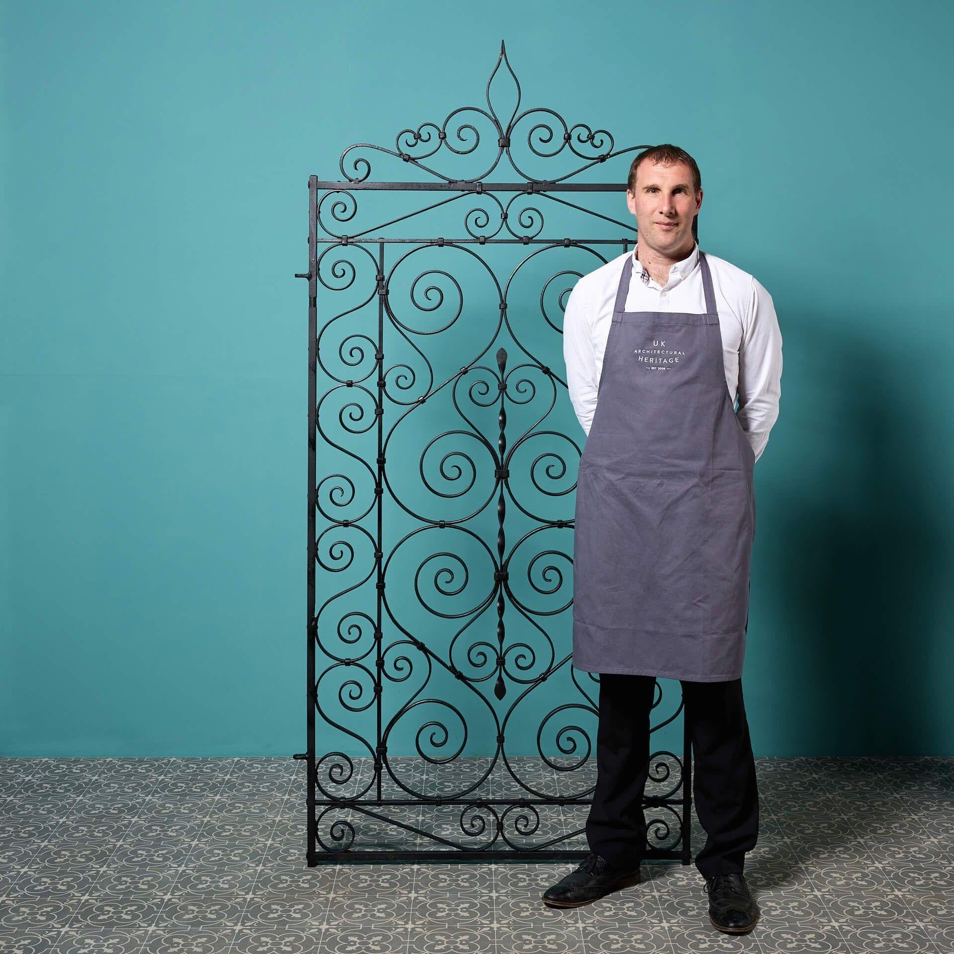 A tall antique Edwardian style scrollwork gate, crafted at the hand of a talented early 20th century blacksmith. With its tall proportions, this antique garden gate is ideal for placement down the side of a house or a narrow-walled garden