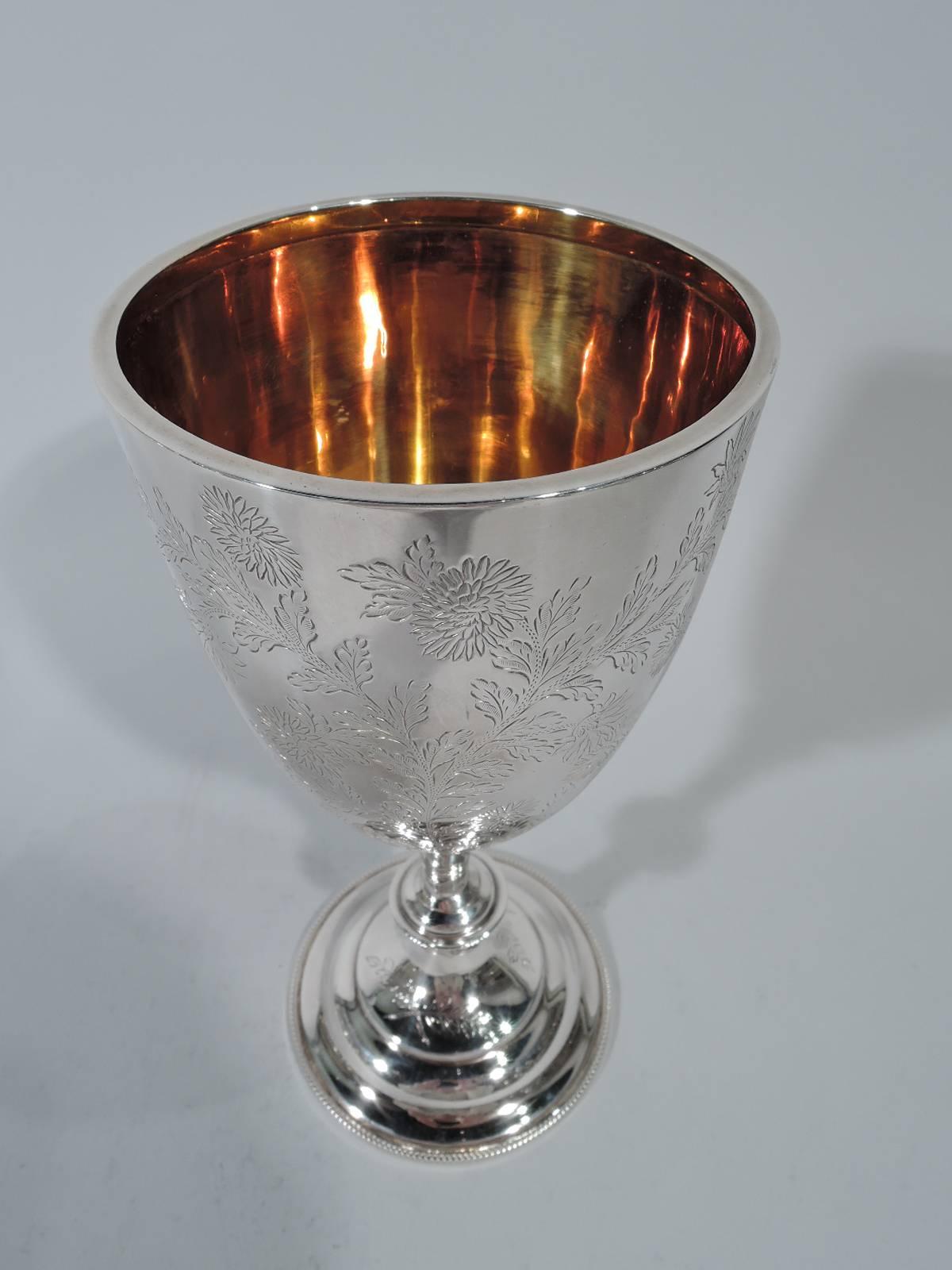 Edwardian sterling silver goblet. Made by Charles Boyton in London in 1901. Ovoid bowl on knopped stem mounted to stepped domed foot. Engraved wildflowers forming two frames (vacant). Interior richly gilt. Hallmarked. Weight: 10.7 troy ounces.