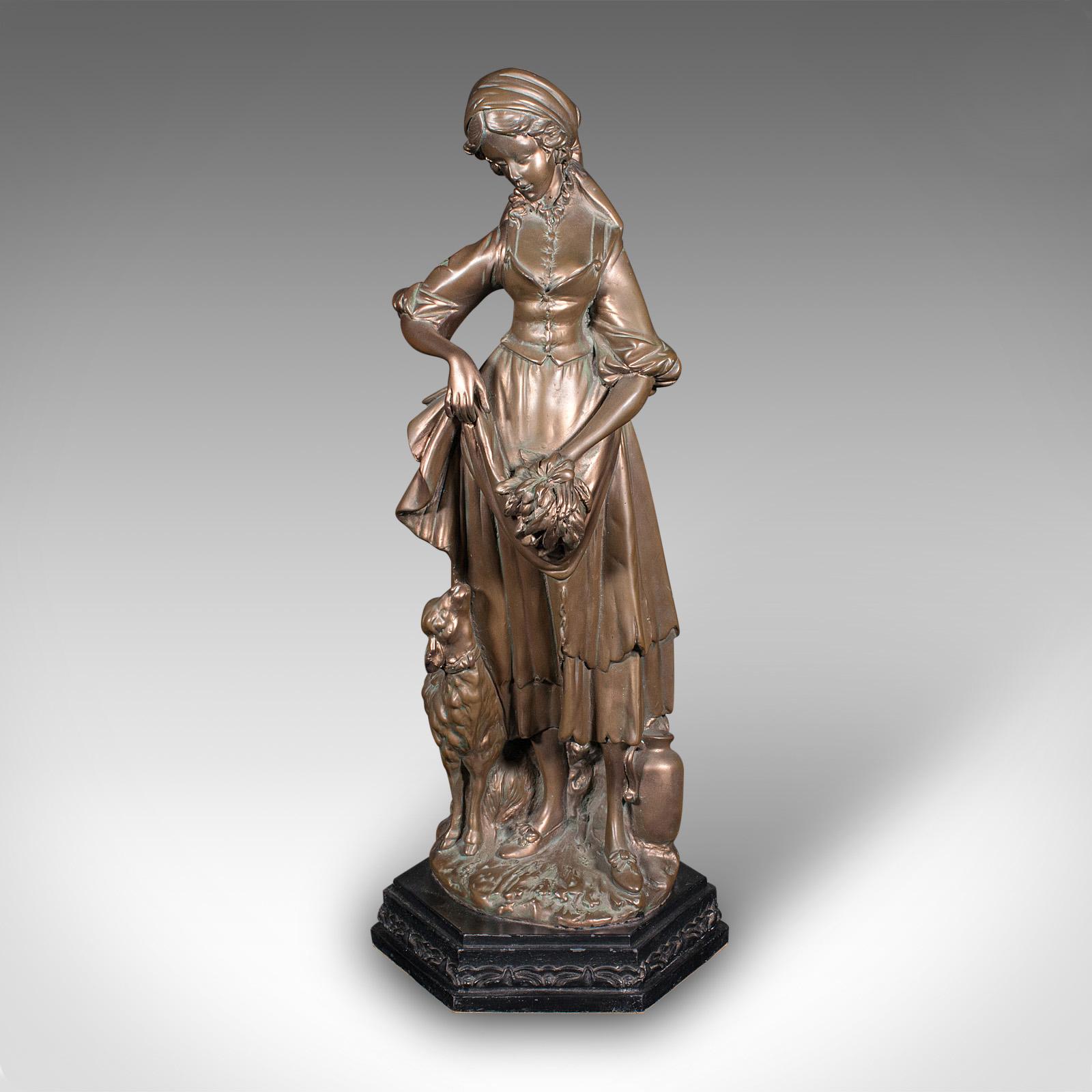 
Se trata de una figura femenina alta y antigua. Estatua austriaca de escayola bronceada, de finales de la época victoriana, hacia 1900.

Graciosa figura de lechera, acompañada de un cordero curioso
Presenta una deseable pátina envejecida y en buen