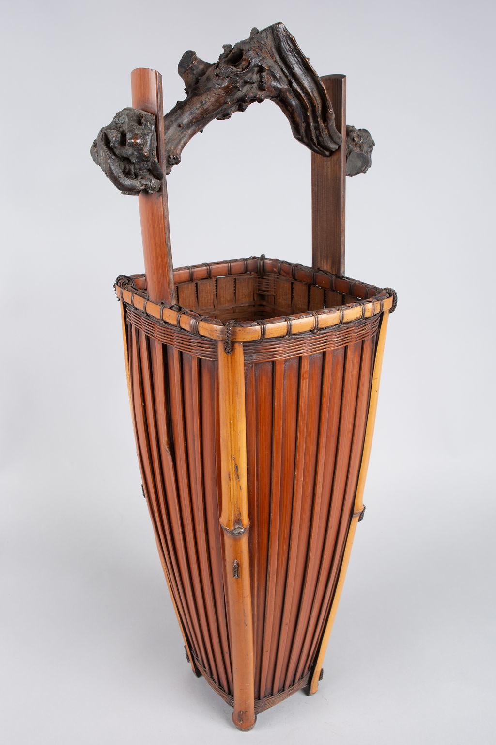 Tall Japanese Antique Ikebana (Flower Arranging Basket). Tall, stylish flower arranging basket with a great multi-toned design and very nice woven knot details. Meiji period (1868-1912), made of smoked and polished bamboo with a natural root handle.