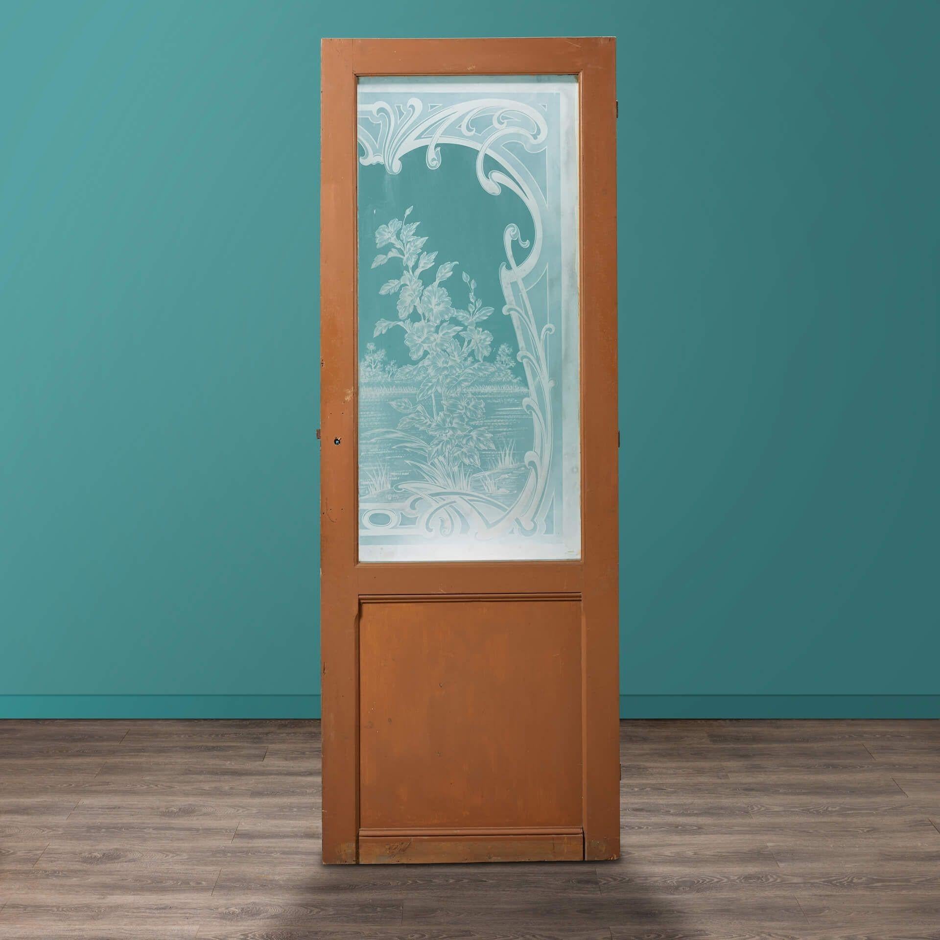 A tall antique pitch pine acid etched glazed door. The main panel is artistically glazed with an acid etched riverbank scene depicting flowers, shrubbery, and surrounding scrolls.

In Louis style with a painted pine finish, this exquisite door is a