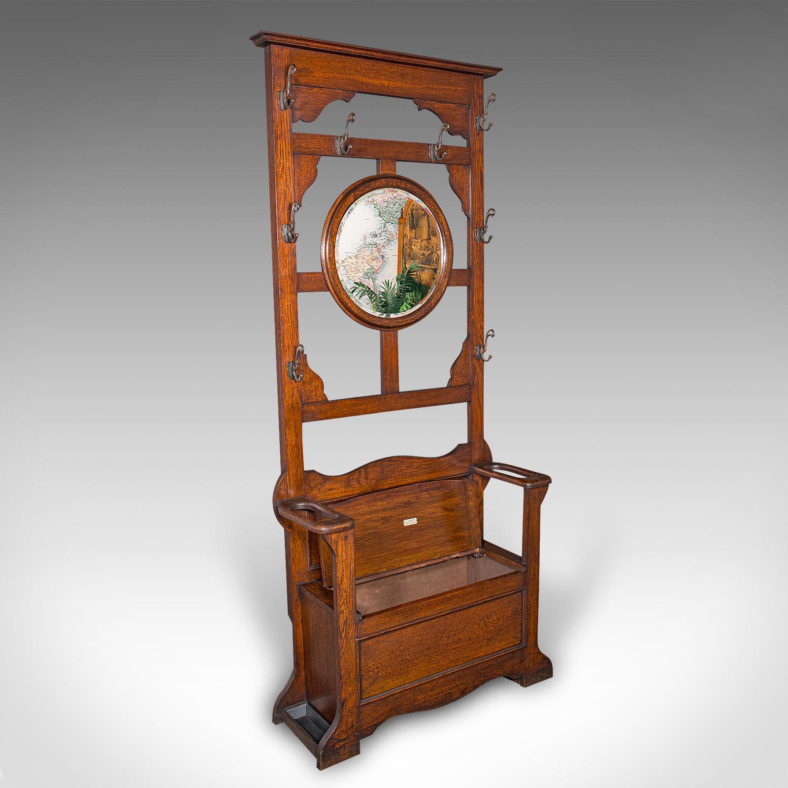 
This is a tall antique seated coat stand. An English, Oak hall rack with valet mirror, dating to the Edwardian period, circa 1910.

Superb reception hall piece with a generous height of 6' 7''
Displays a desirable aged patina and in good order