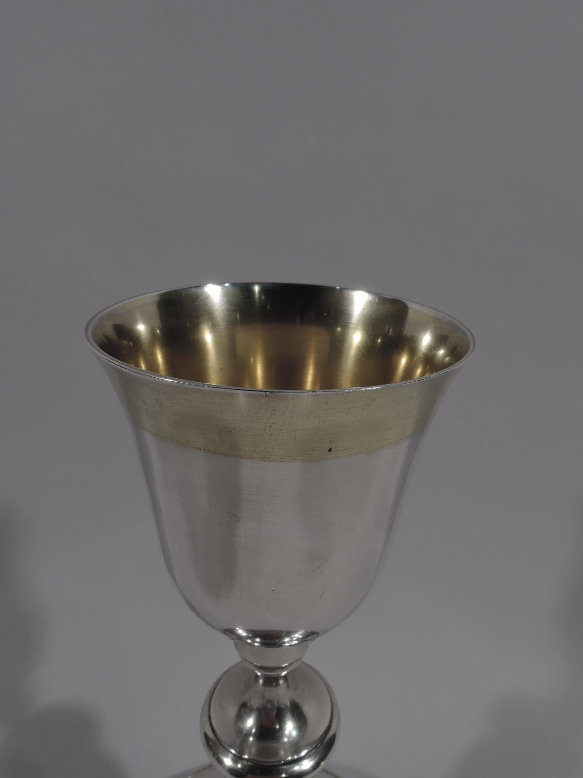 Tall silver chalice, first half of the 19th century. Baluster shaft with knop, ball, and spool on stepped and domed foot. Tapering bowl with flared rim. Bowl interior and rim exterior gilt-washed. Marked “J V / Lorenzo”. Weight: 11 troy ounces.