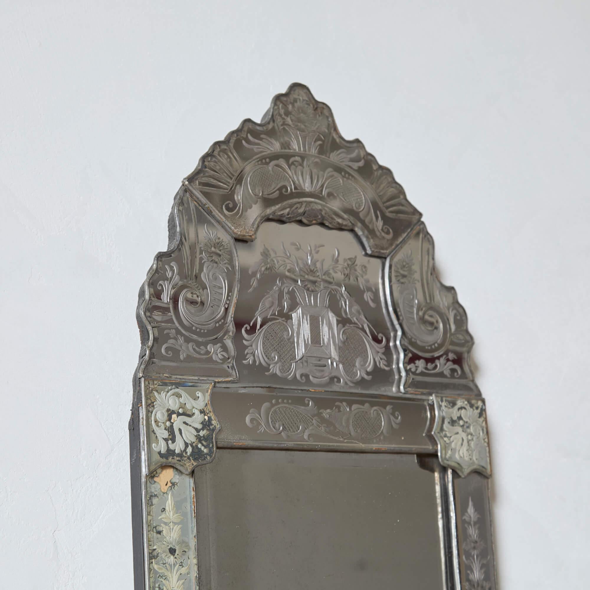 A delicately etched venetian mirror decorated with floral and foliate motifs.
