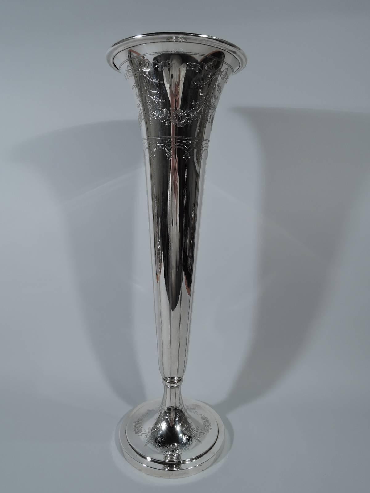 Tall Edwardian sterling silver trumpet vase. Made by Whiting in New York in 1913. Cone with flared rim and raised foot. Engraved ornament: Floral garland above pointille foliate arcade with pendant vertical lines. Another garland on foot. Hallmark