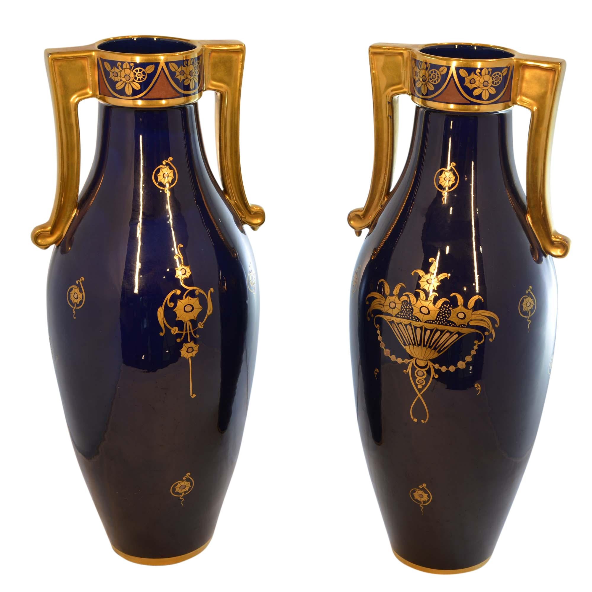 These large-scale beautiful cobalt blue porcelain vases have matching art deco floral design on fronts and coordinating backs with a more simplistic floral feature. The sides have dainty repeat pattern. Hand painted in a lovely gold that looks so