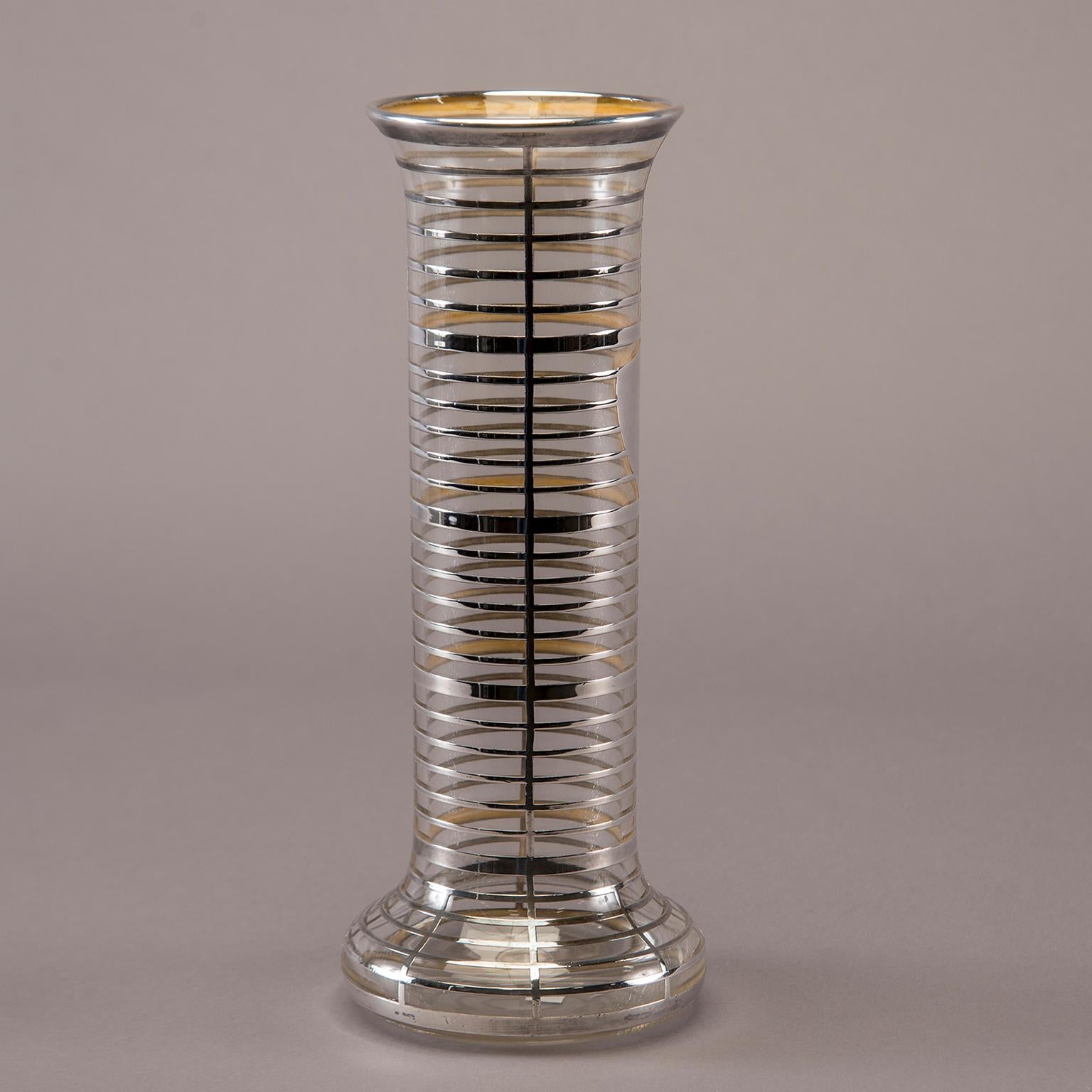Tall clear glass vase features a wide base and heavy silver overlay in a banded grid pattern with shield form, circa 1940s. Unknown maker.