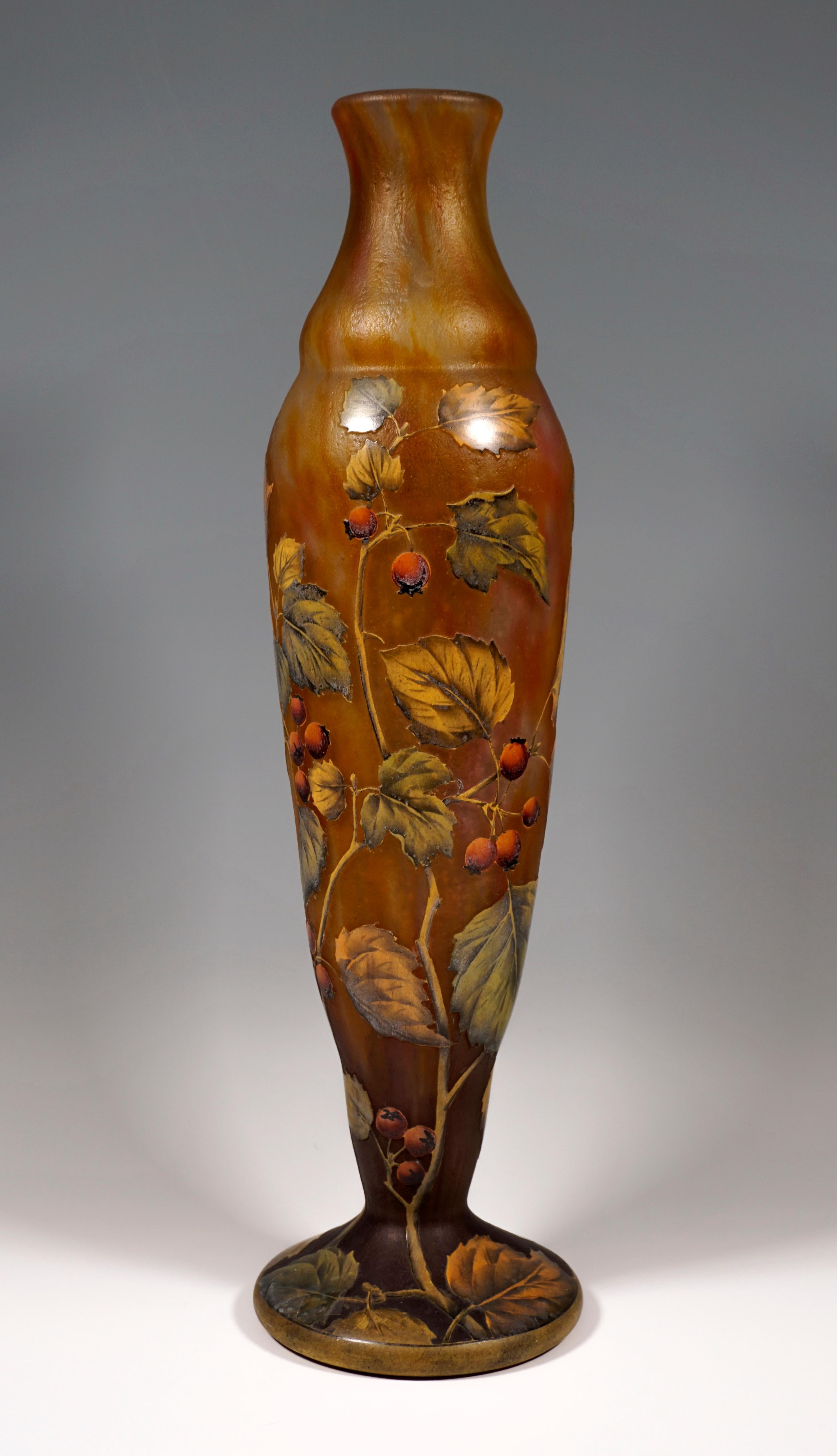 Baluster-shaped vase, colorless glass with milky-yellow-red, in the stand area with brown powder melts, etched, satined, structured surface, rose hip decoration worked out in high section and painted with colored enamel, expansive base with polished