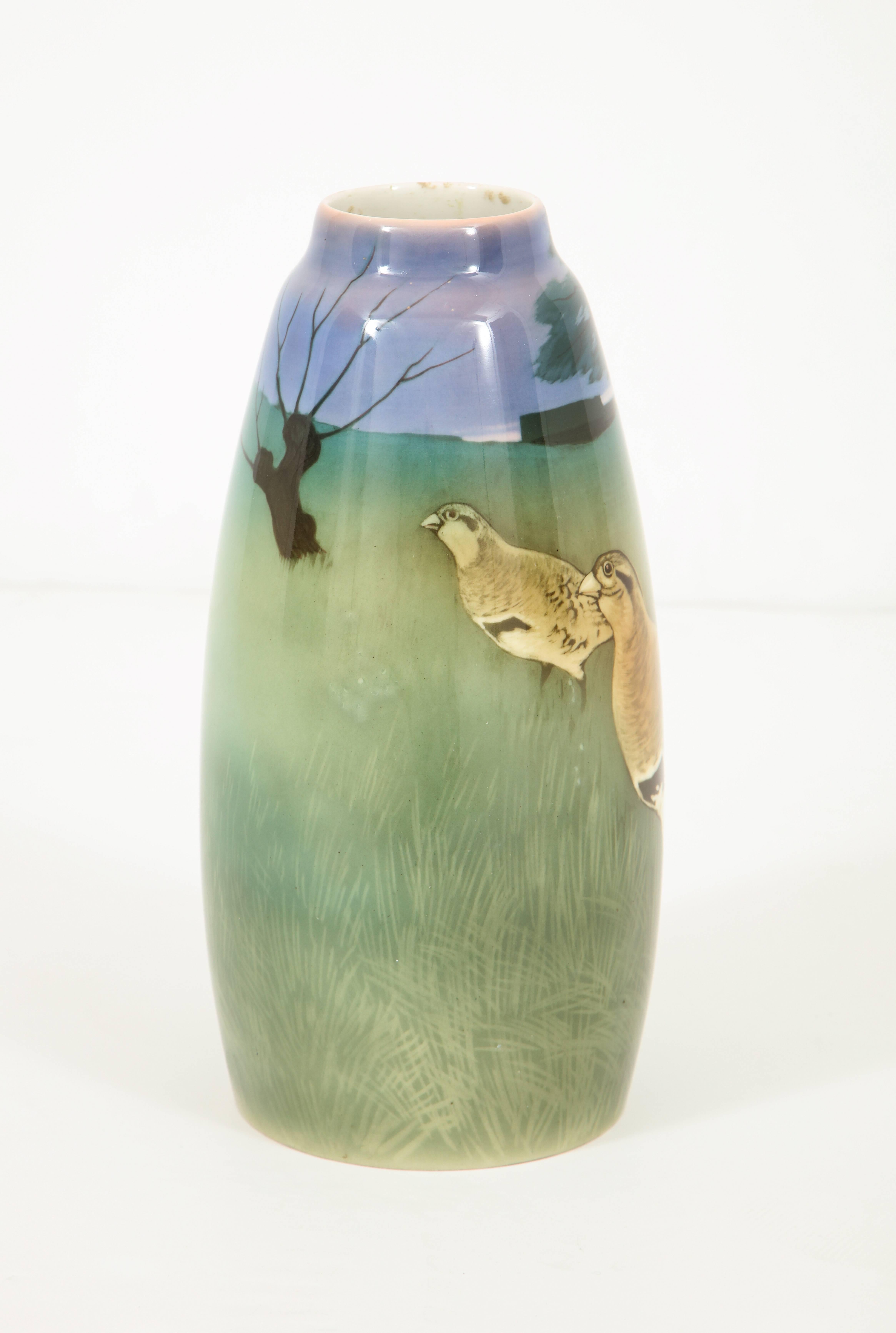 Tall, beautifully decorated Art Nouveau vase by Nils Emil Lundstrom 1895-1960. Sophisticated and haunting scene meanders around the entire vase. Elements include a pair of guinea fowl, trees, sky and field. Nils Emil Lundstrom was a painter,