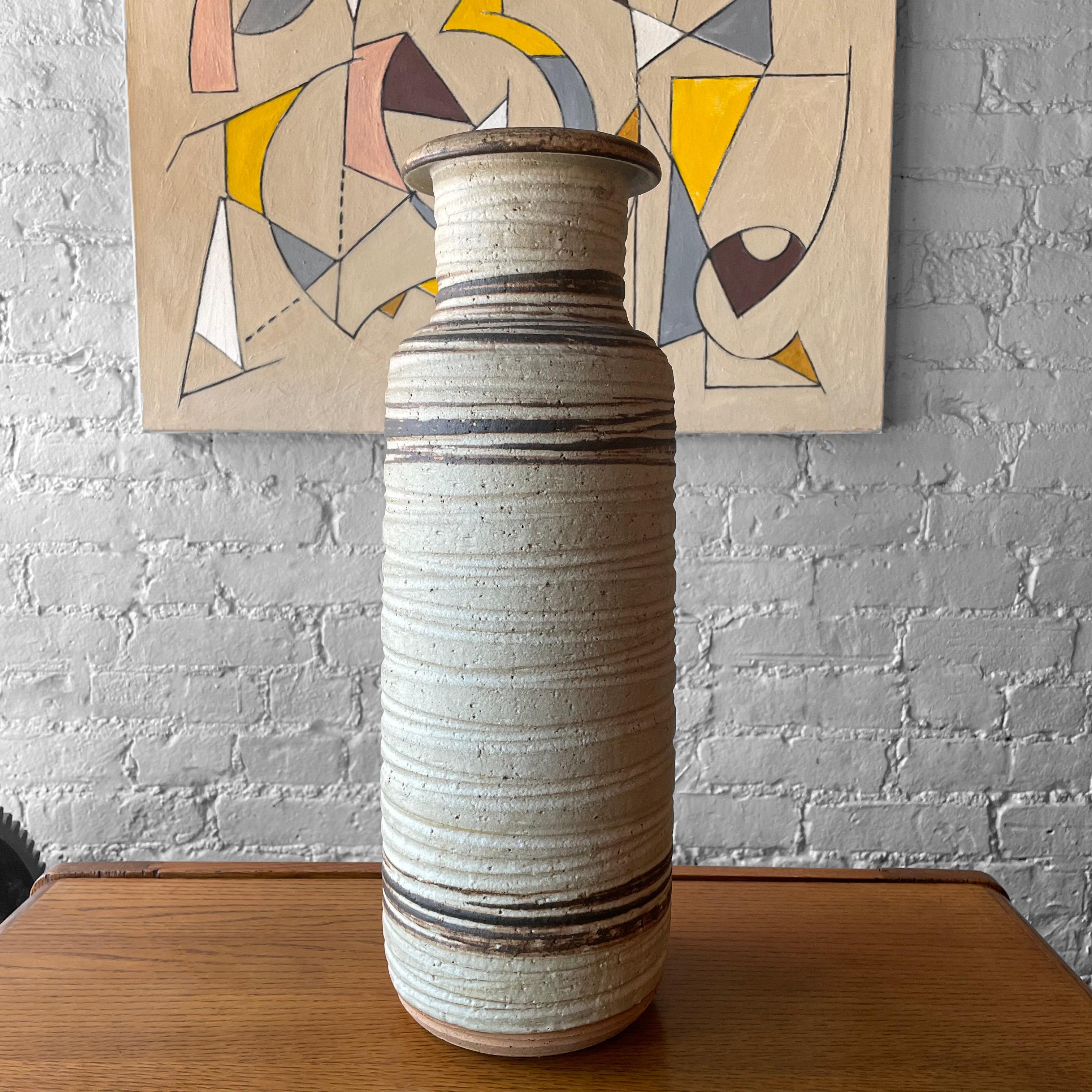 Tall, art pottery vase by Bitossi for Rosenthal Netter, attributed to Aldo Londi features an incised, matte glaze in varied eathern tones. The mouth opening is 3.5 inches.