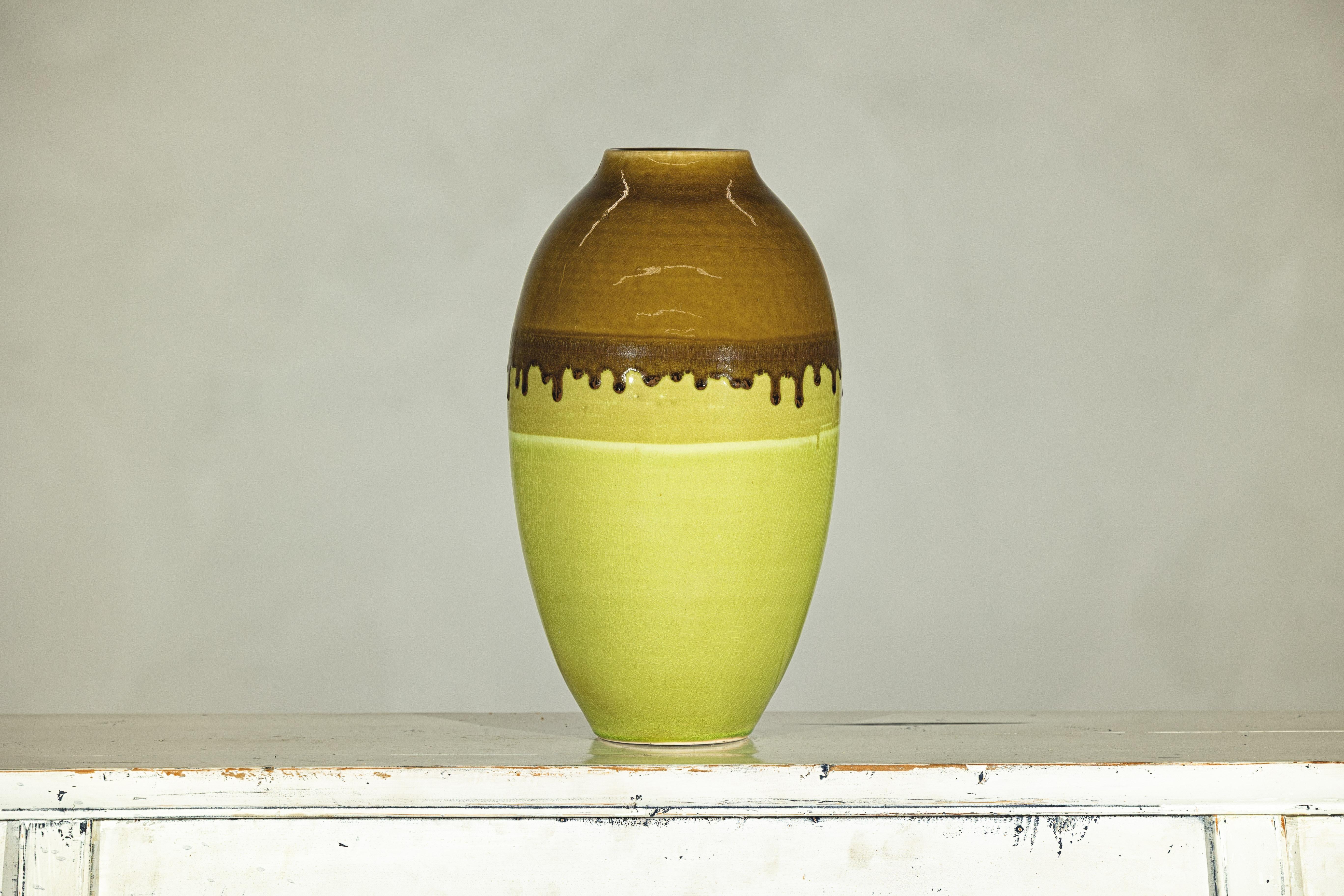 With its striking palette and bold visual rhythm, this artisan-crafted ceramic vase offers a confident accent for contemporary interiors. Hand-thrown and glazed, the tall ovoid form is defined by a high-shouldered silhouette and a relatively narrow