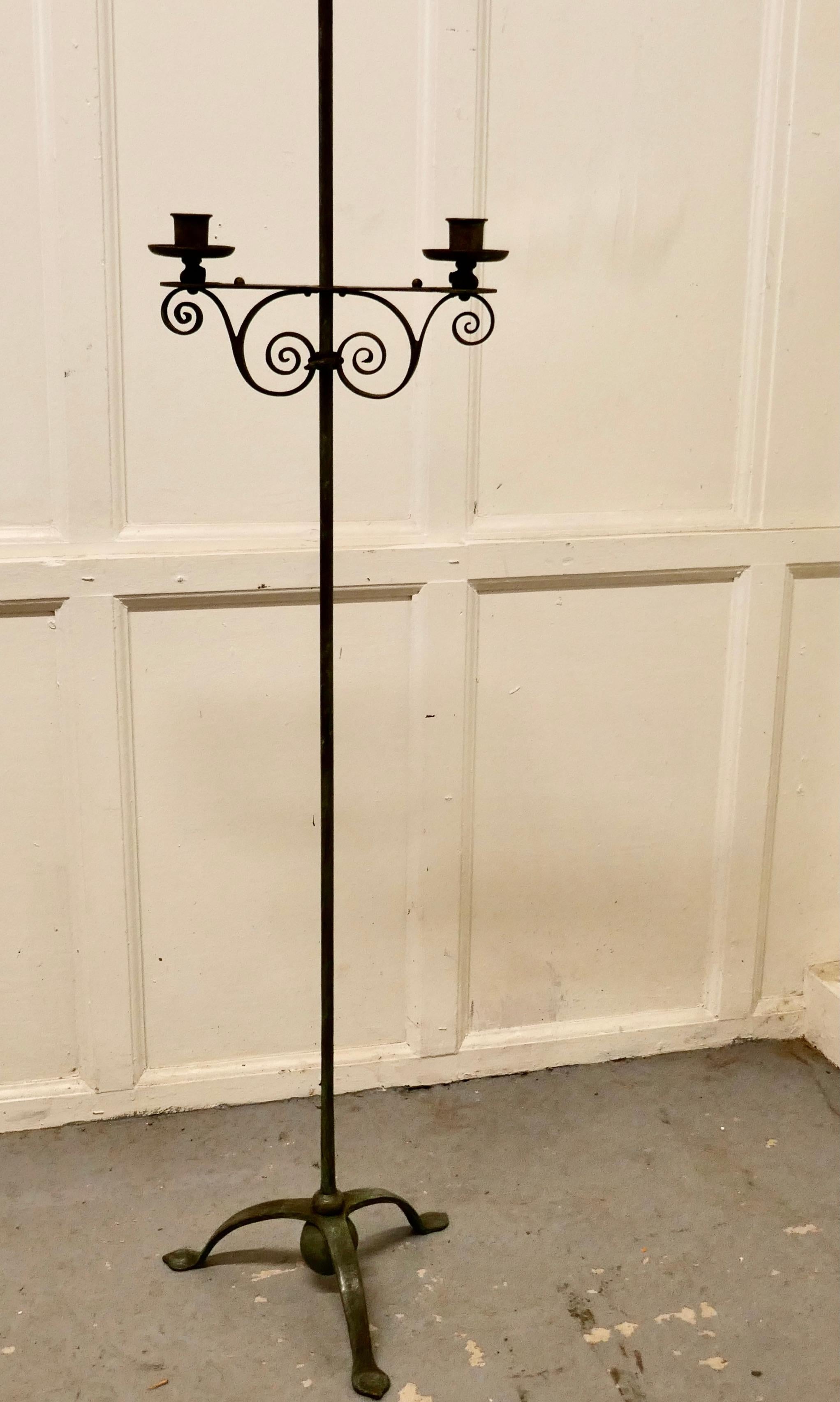 Tall arts and crafts wrought iron candle stick or torchère

This is a tall torchere, it takes 2 candles and these can be raised or lowered to suit
The stand is blacksmith made, it has been kept well and has a slightly verdigris patina and is not