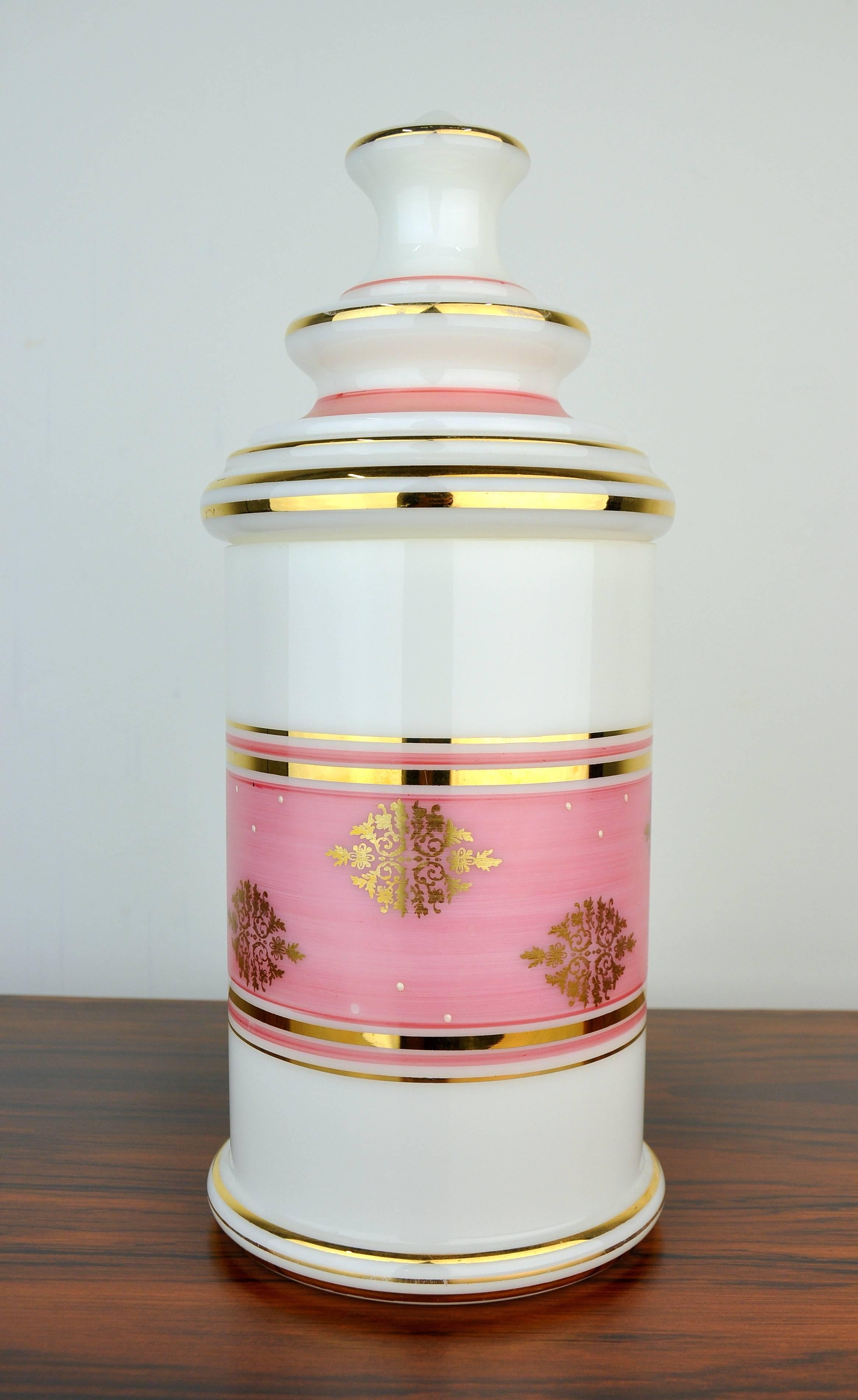 A superb large-scale 19th century example of an antique French enameled, gilt and painted opaline glass apothecary or dresser jar, attributed to Baccarat. The white opaline glass is decorated with alternating pink and gilded bands, and further