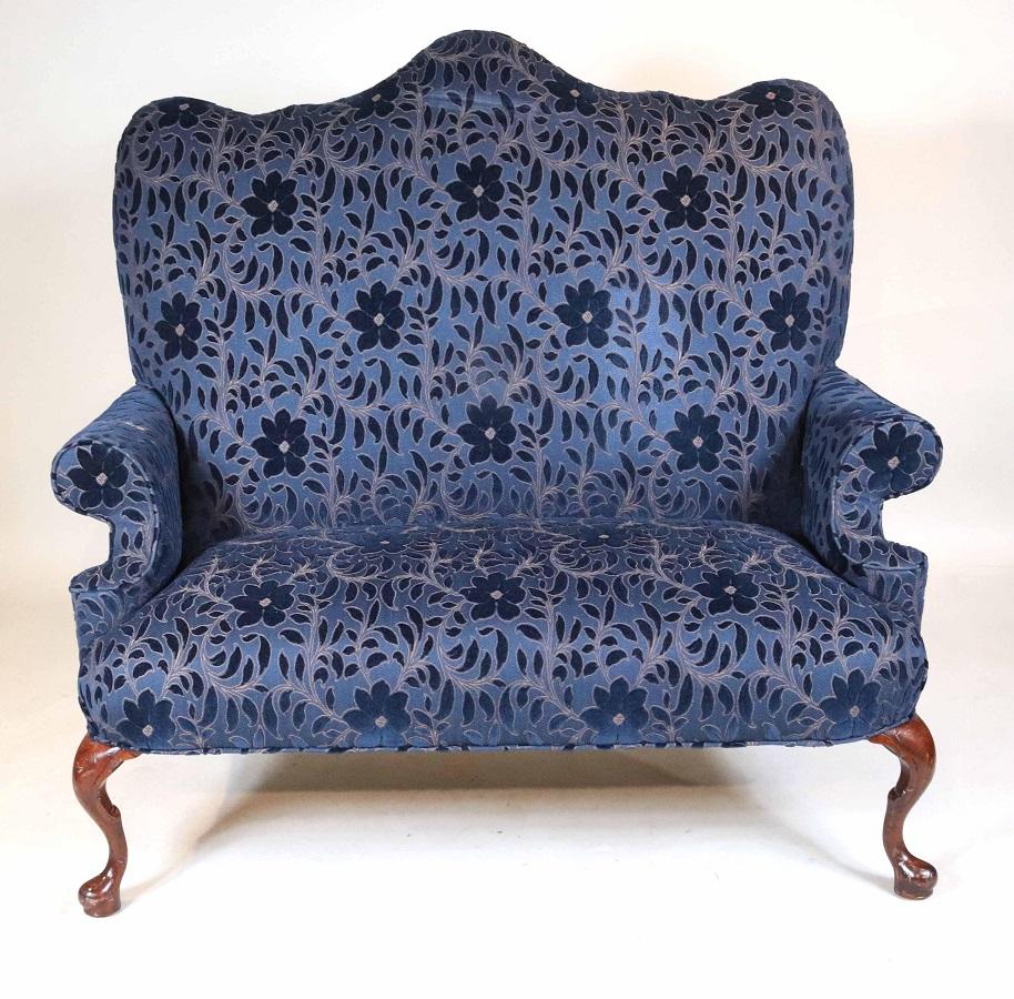 Tall back Queen Anne style Loveseat with blue velvet upholstery and solid walnut legs.
