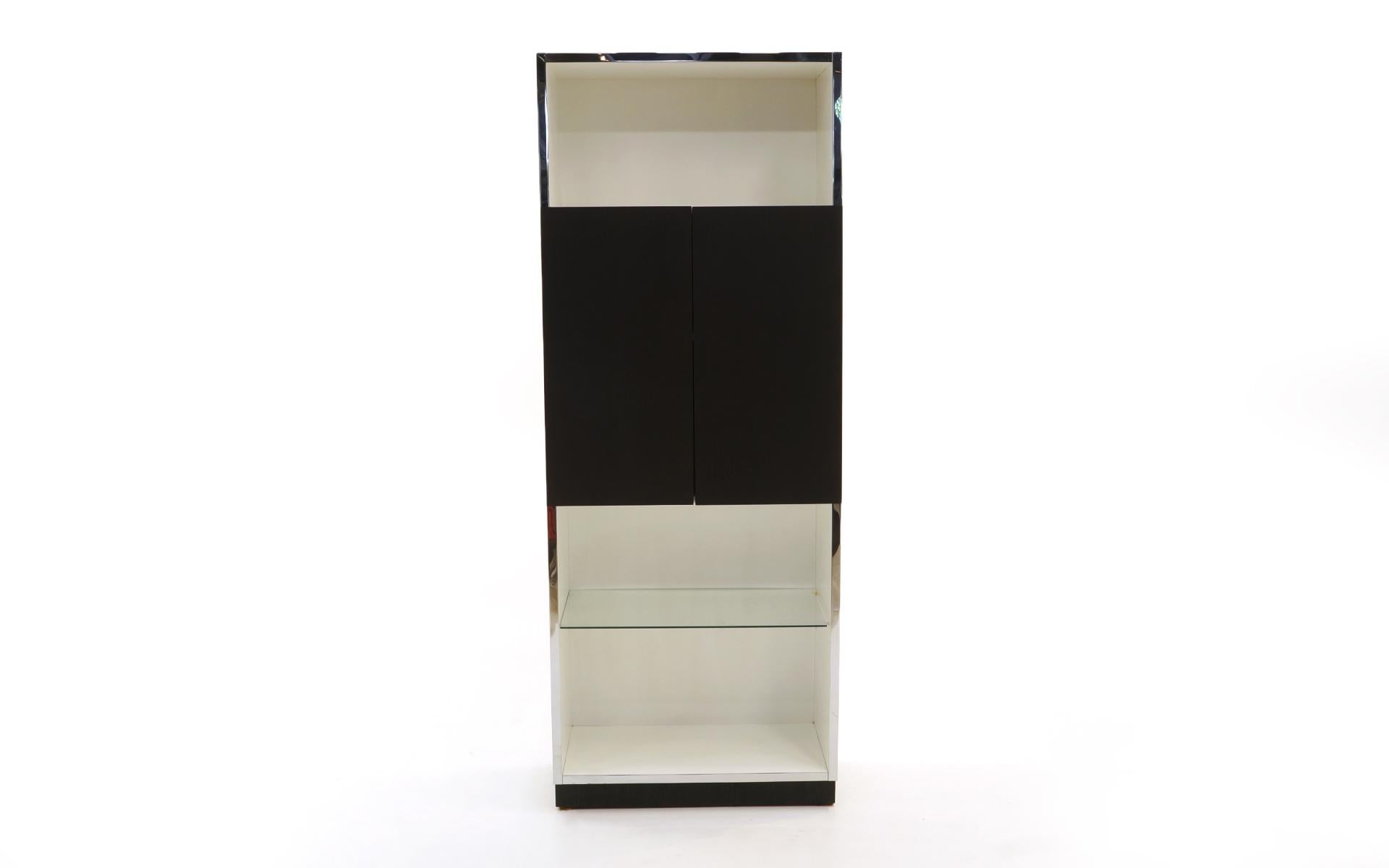 Milo Baughman tall cabinet. All the shelves are adjustable so can be used for many types of storage or display. It has been used as a bar cabinet. The white lacquered surfaces are in very good to excellent condition as is the chrome, glass, and