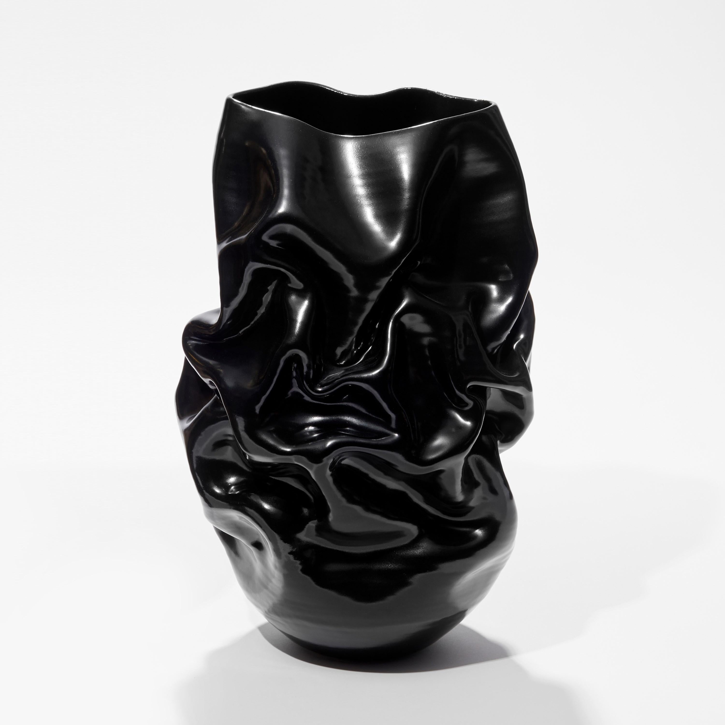 ‘Tall Black Crumpled Form No 94’ is a unique sculptural vessel by the British artist, Nicholas Arroyave-Portela.

Nicholas Arroyave-Portela’s professional ceramic practise began in 1994. After 20 years based in London, he moved and set up his