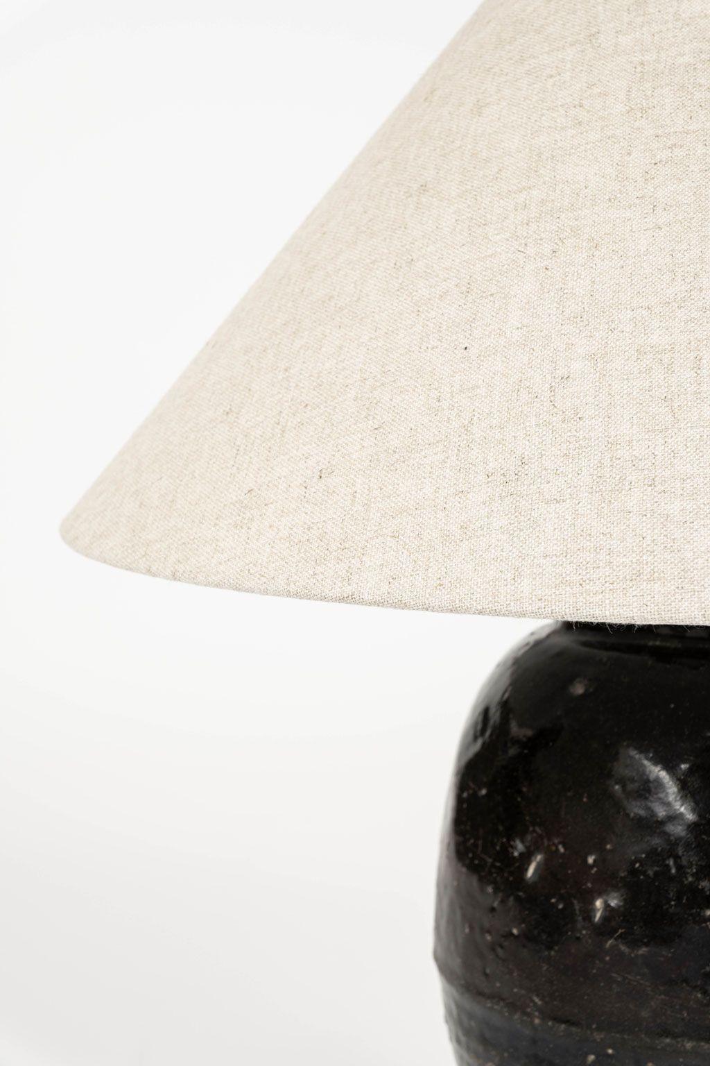 Tall black glazed pottery table lamp with linen shade. Newly wired for use within the USA with line switch.