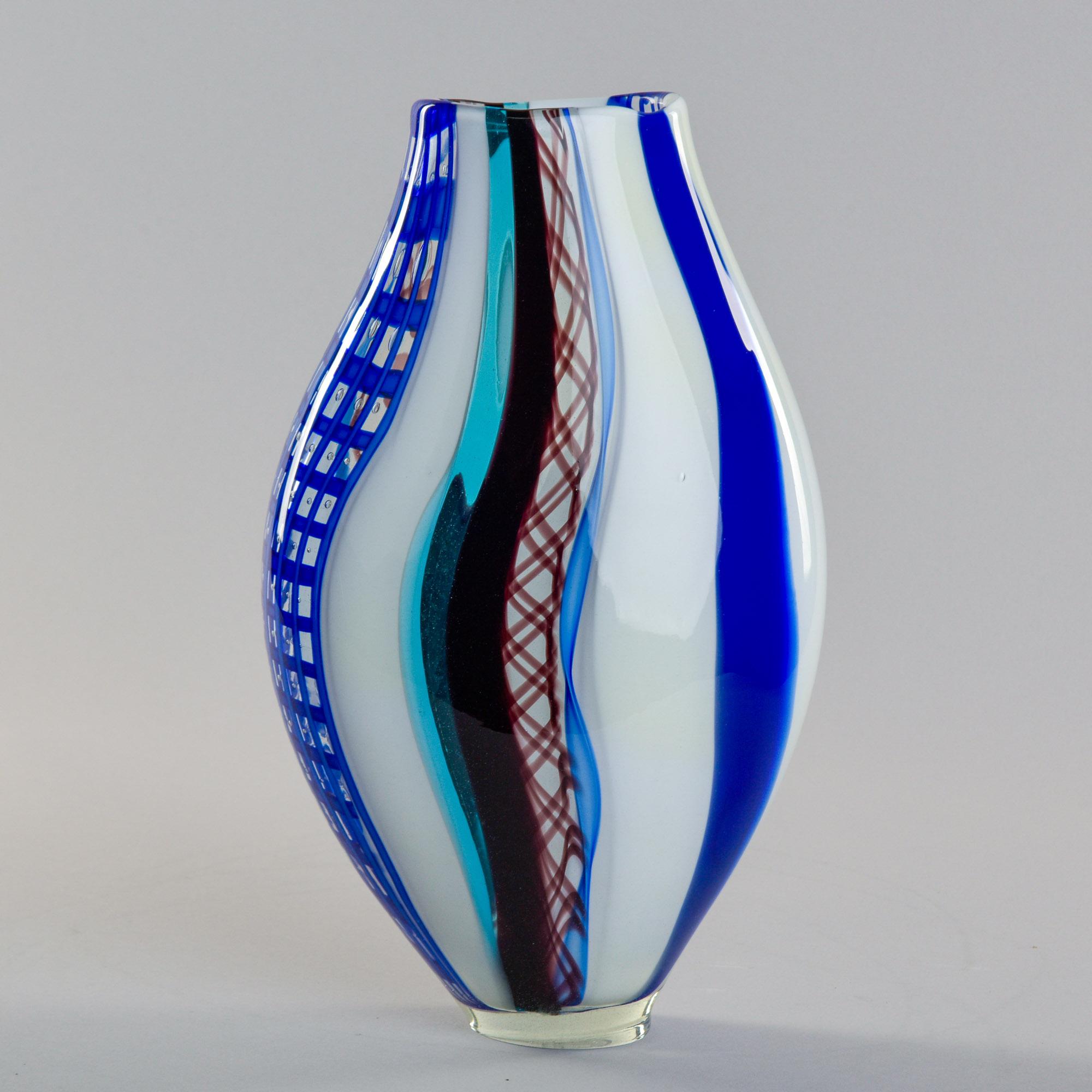 Trovato in Italia, questo vivace vaso in vetro di Murano risale alla fine degli anni '90, inizio 2000. Forma ovoidale alta nei toni del blu e del bianco con accenti di reticolo chiari e neri. Il vaso presenta la firma incisa di Fabiano Zanchi sul