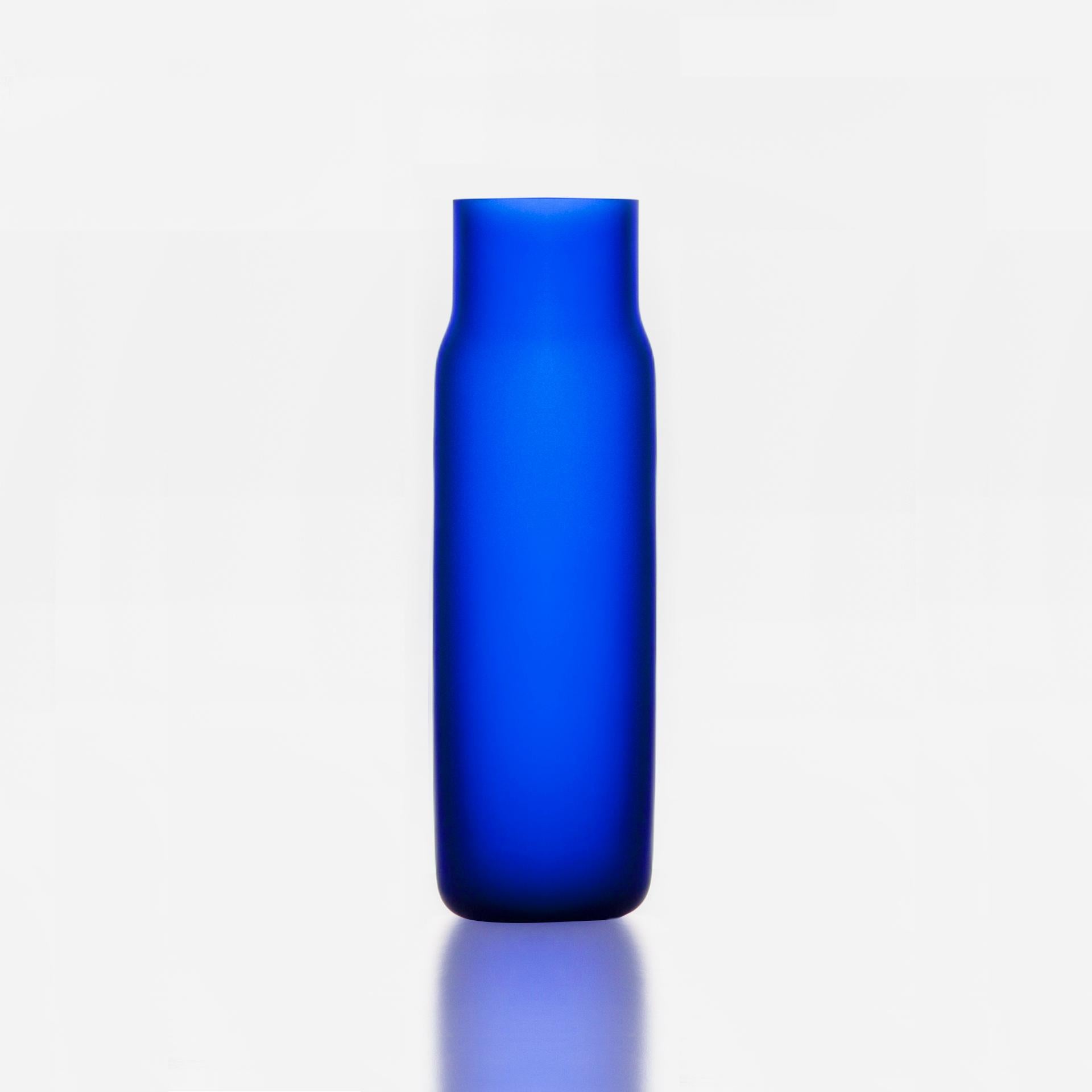 Vaso alto Blue Bandaska Matte di Dechem Studio A.
Dimensioni: D. 9 x H. 31 cm.
Materiali: vetro.
Disponibile in 4 dimensioni: D15 x H25/ D18 x H24/ D9 x W31/ D22 x H33 cm.
Disponibile in nero, giallo uranio e blu scuro.

Soffiata a mano in uno