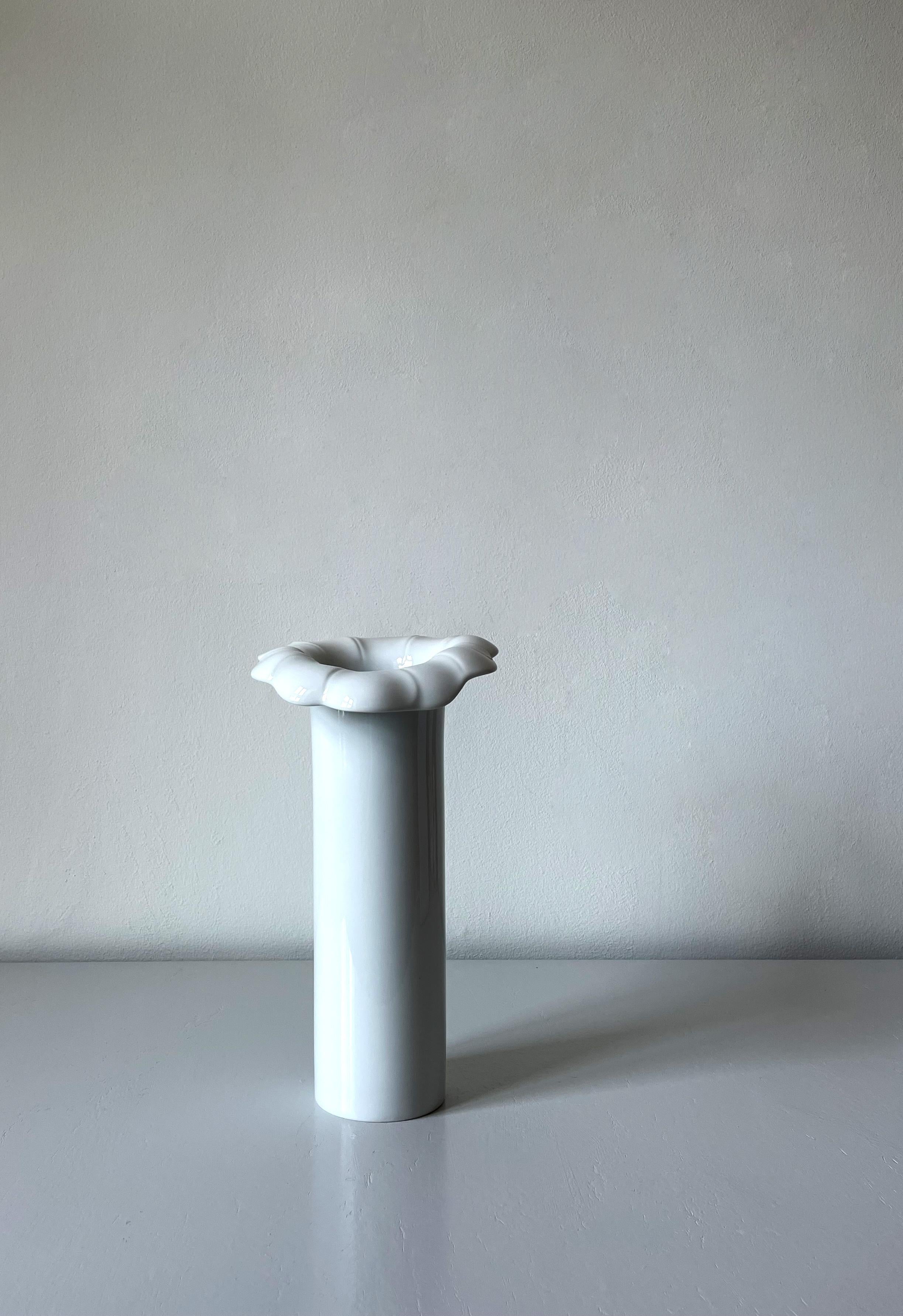 Tall and slender bone white sculptural porcelain vase. Smooth clean cylinder shape with soft asymmetrical organic floral collar. Stamped under base. 
Beautiful vintage condition. 
Arzberg, Germany, 1980s.