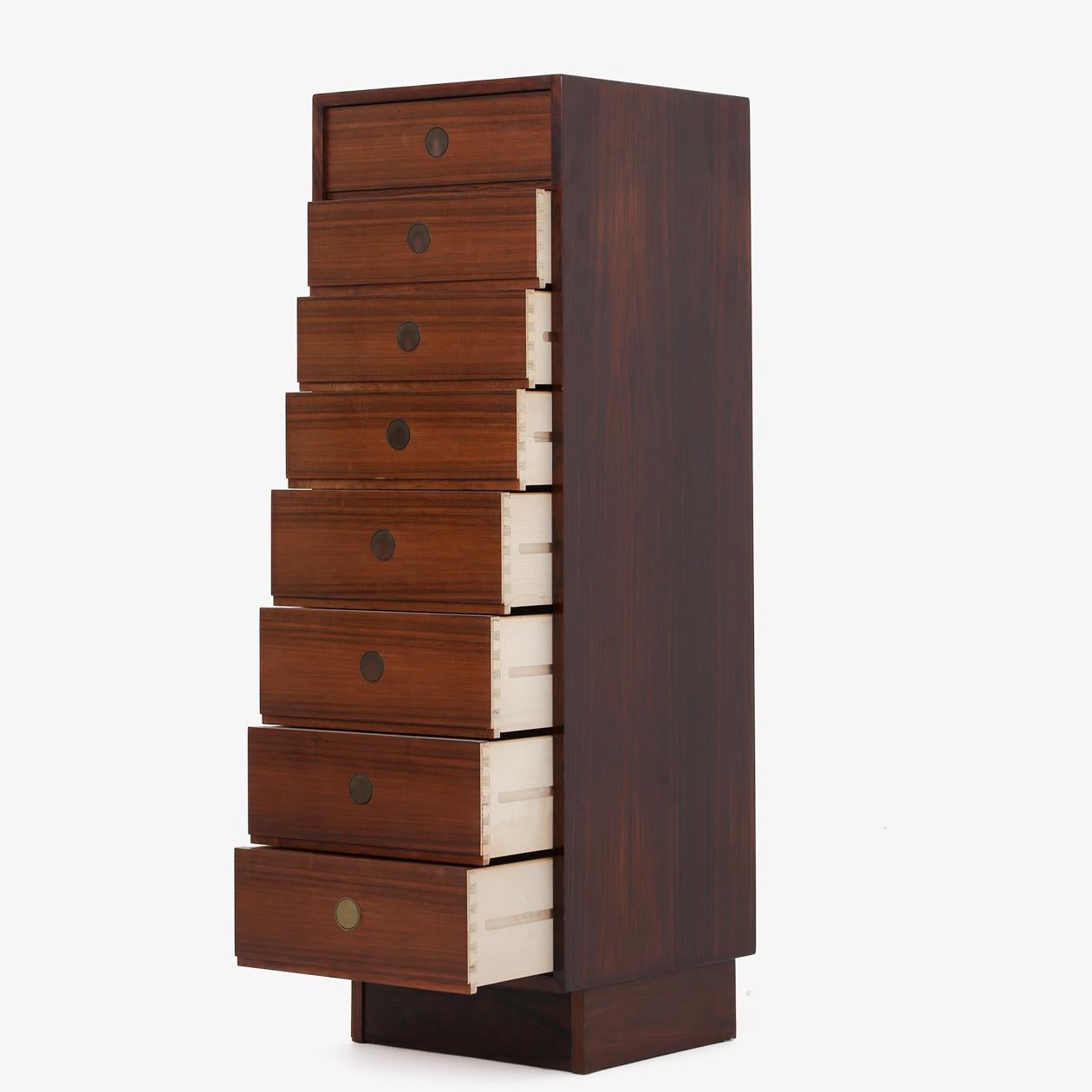Tall chest of drawers in rosewood with brass handles. Maker Dyrlund.