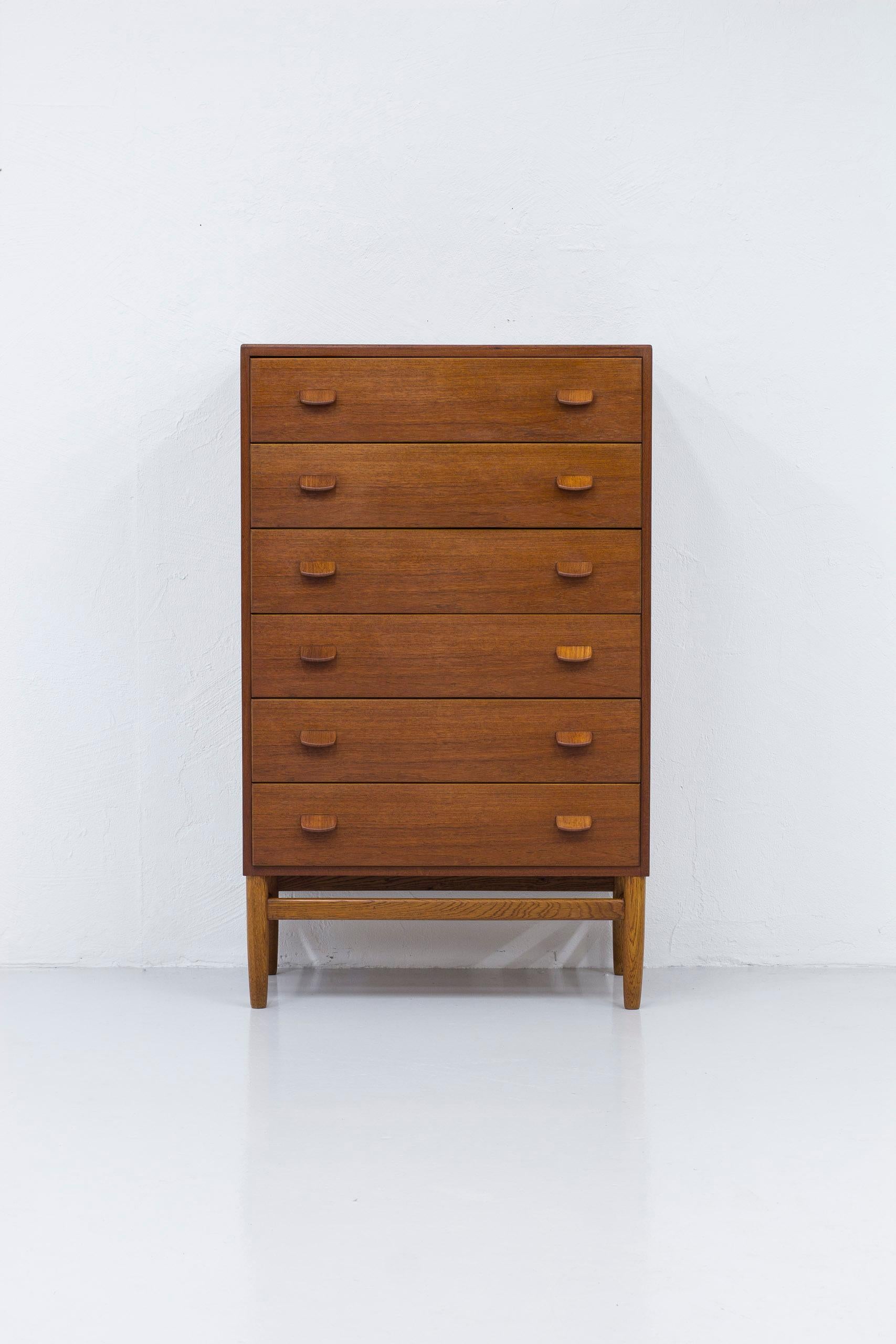Tall boy chest of drawers by Poul M. Volther. Produced in Denmark by FDB during the 1950s. Teak wood on the body, standing on solid oak legs. The inside of the drawers made from lighter maple wood. Very good vintage condition with light signs of age