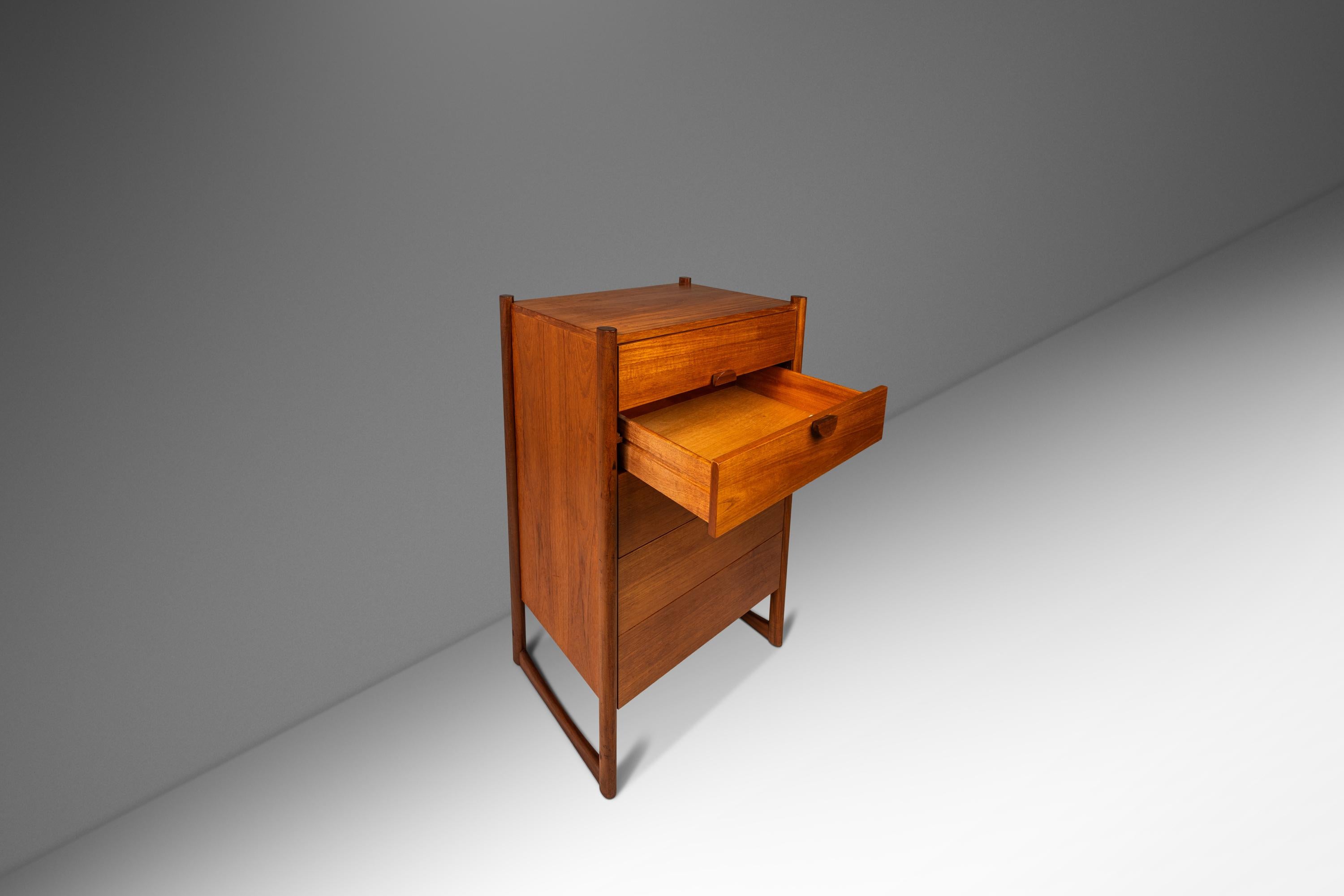 Introducing a rare and versatile tall-boy five-drawer dresser made by Durable Suites in Denmark in the mid-1970's. Constructed from a mix of solid and veneered Burmese teak with exceptional old growth woodgrains this dresser features a stylish