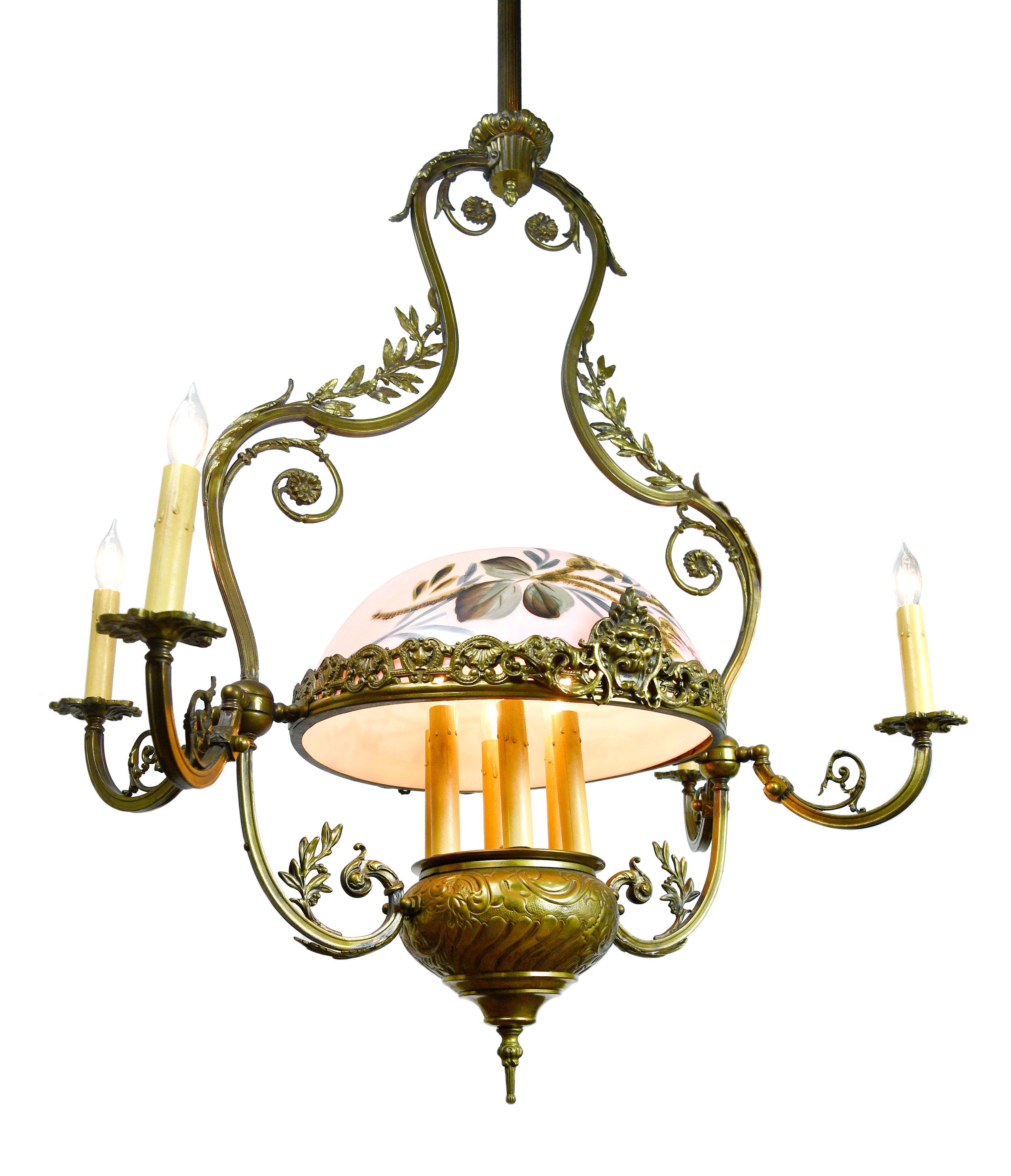 This finely crafted chandelier features intricate detailing within the handsome brass and lovely floral designs throughout both the structure and the shade. The craftsmanship of this extra tall chandelier needs to be seen to believe!