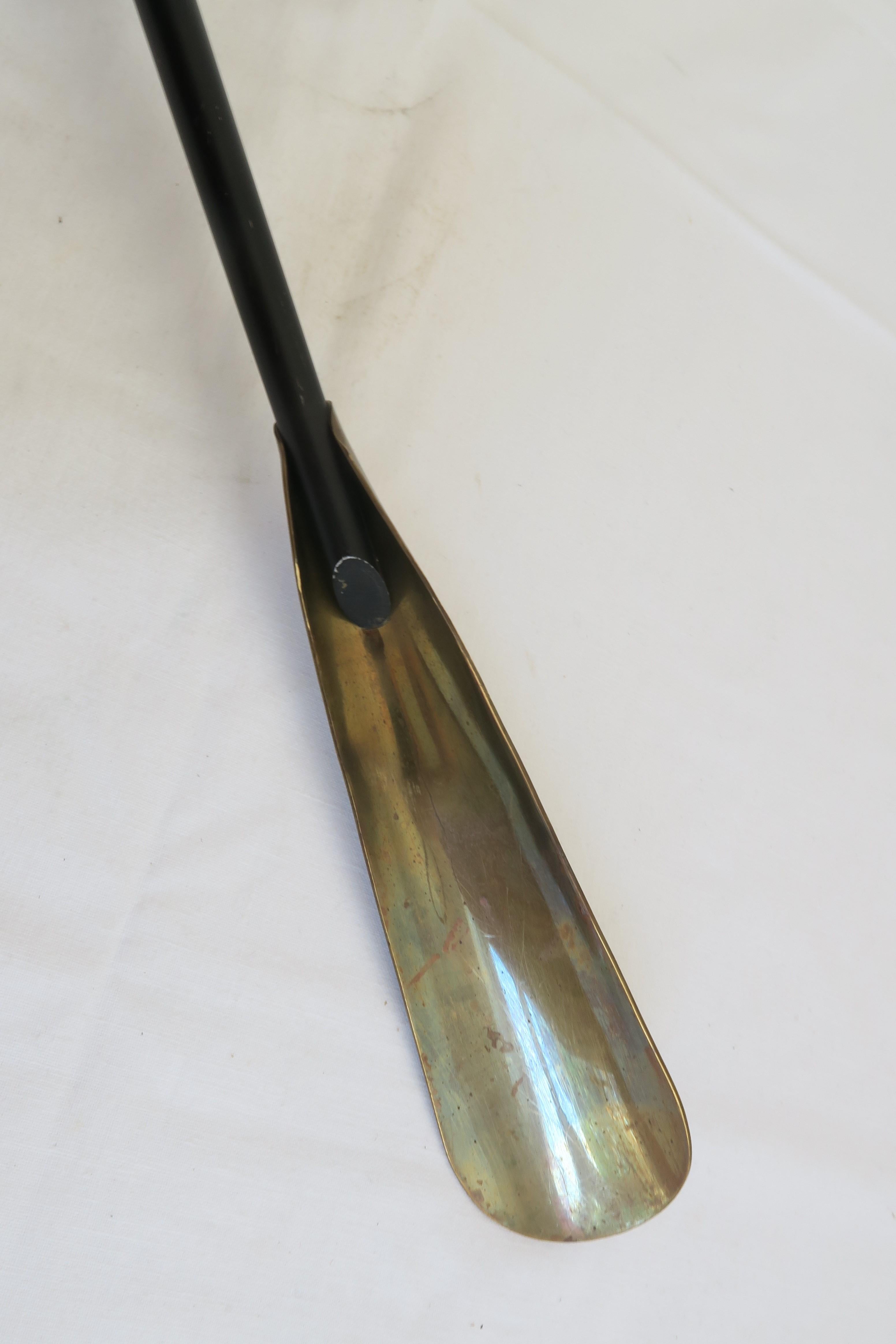For sale is a nice tall shoehorn. It was made from iron which has been painted black, embellished with brass elements and a bright red leather wrapping on the handle. It is representative of Mid-Century design and looks similar to designs of