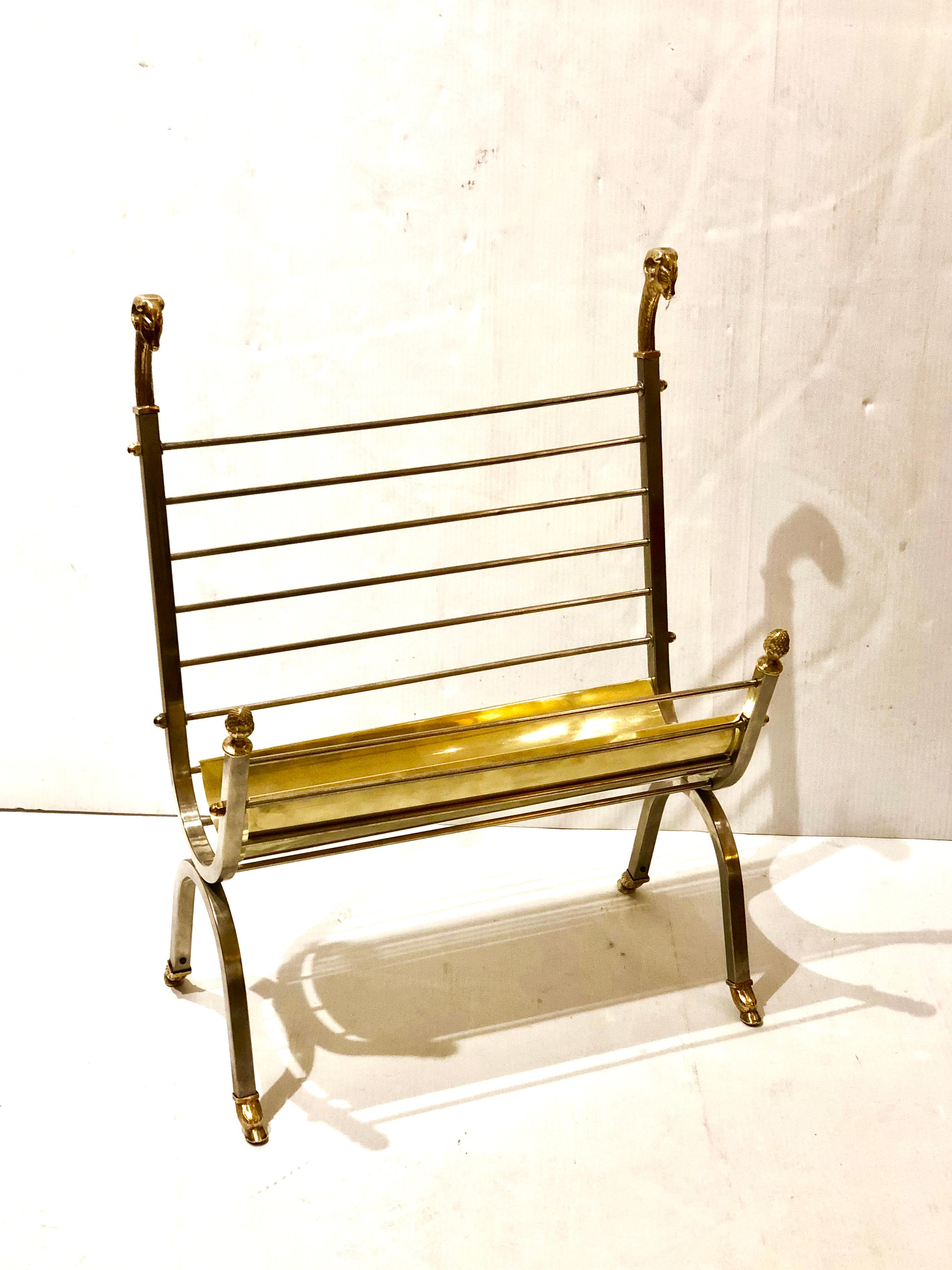 Tall magazine rack in brass and stainless, freshly polished with brass rams heads accents.