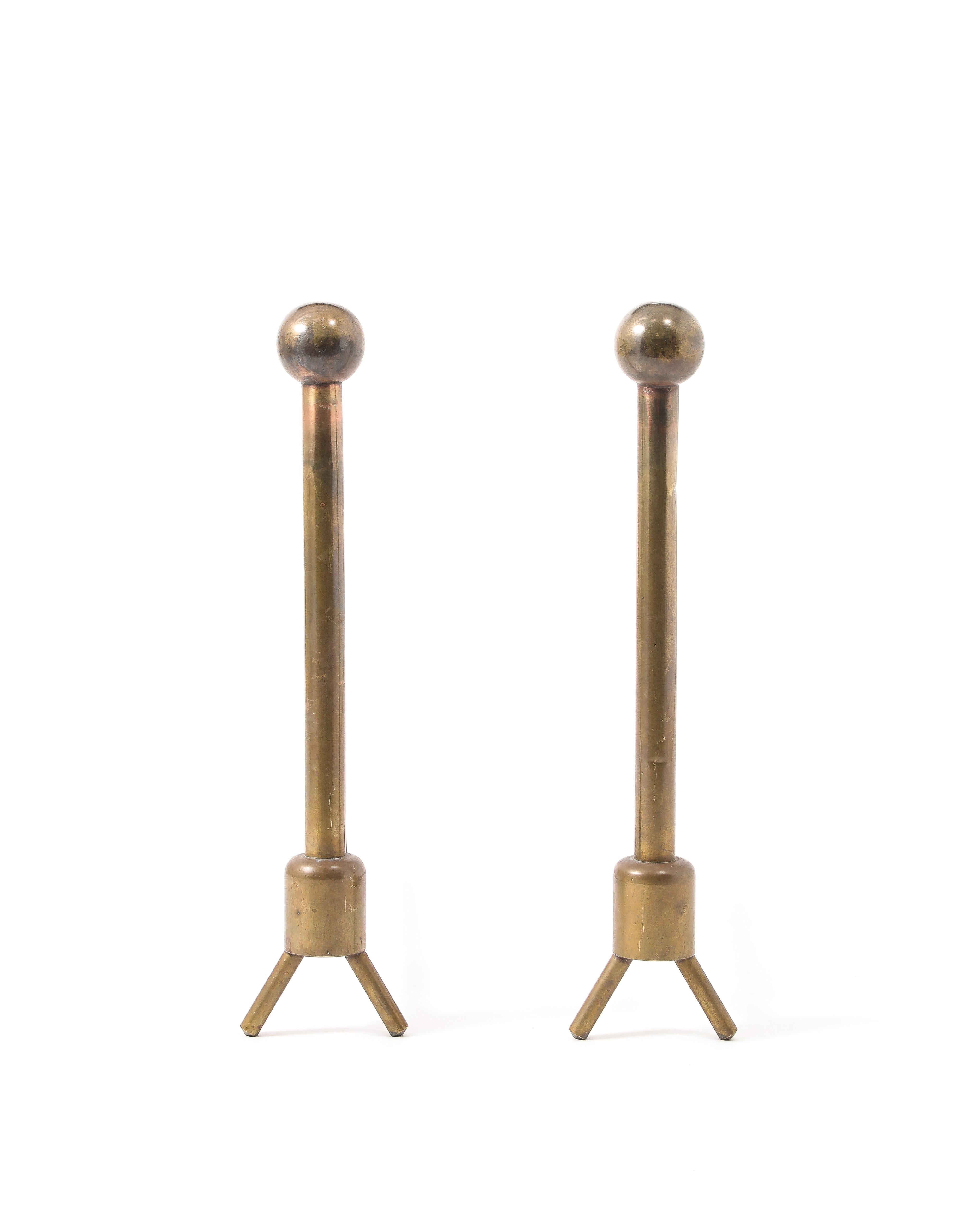 Very tall pair of brass andirons ending in a ball, most likely custom-made.
