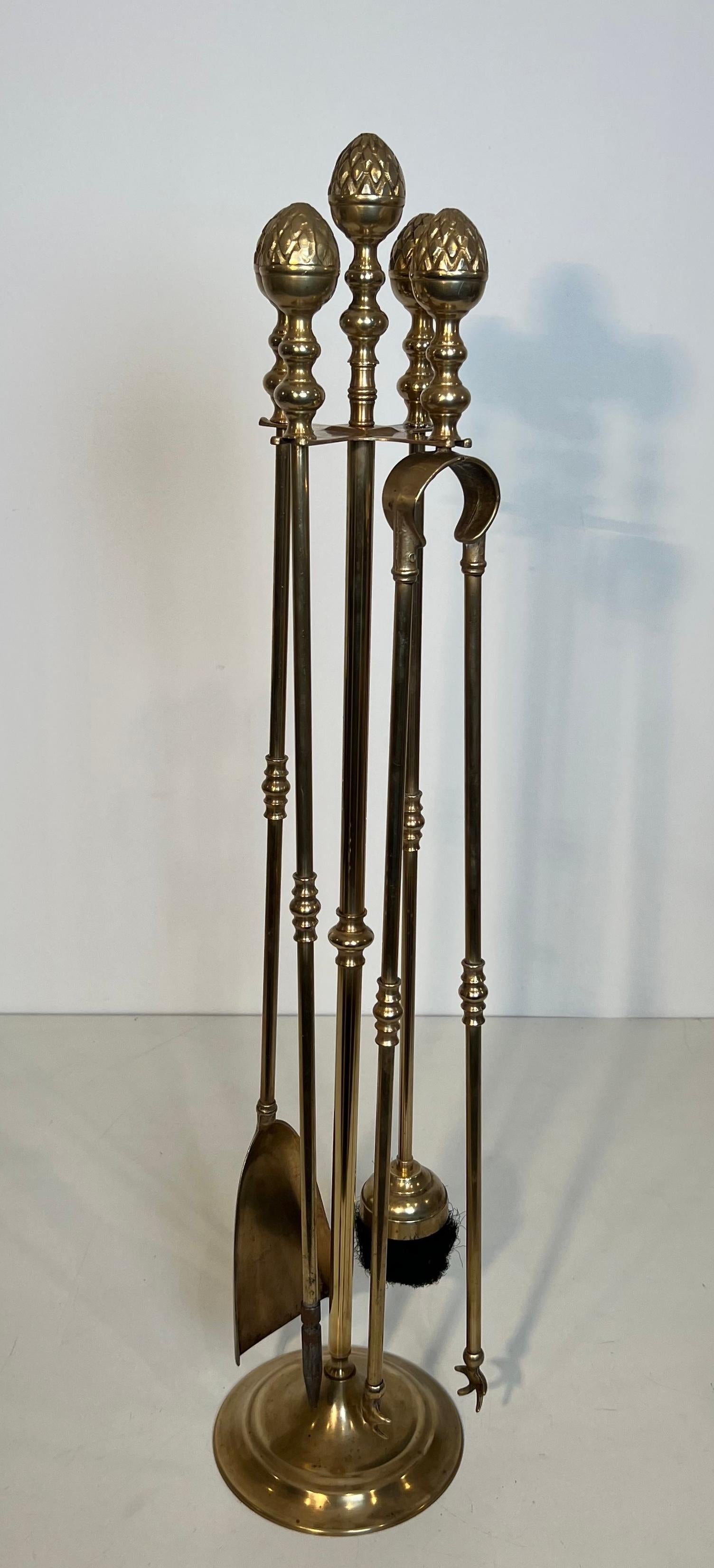 Questo simpatico strumento per caminetto alto in stile neoclassico è realizzato in ottone. Si tratta di un'opera francese nello stile della Maison Baguès. Circa 1970
