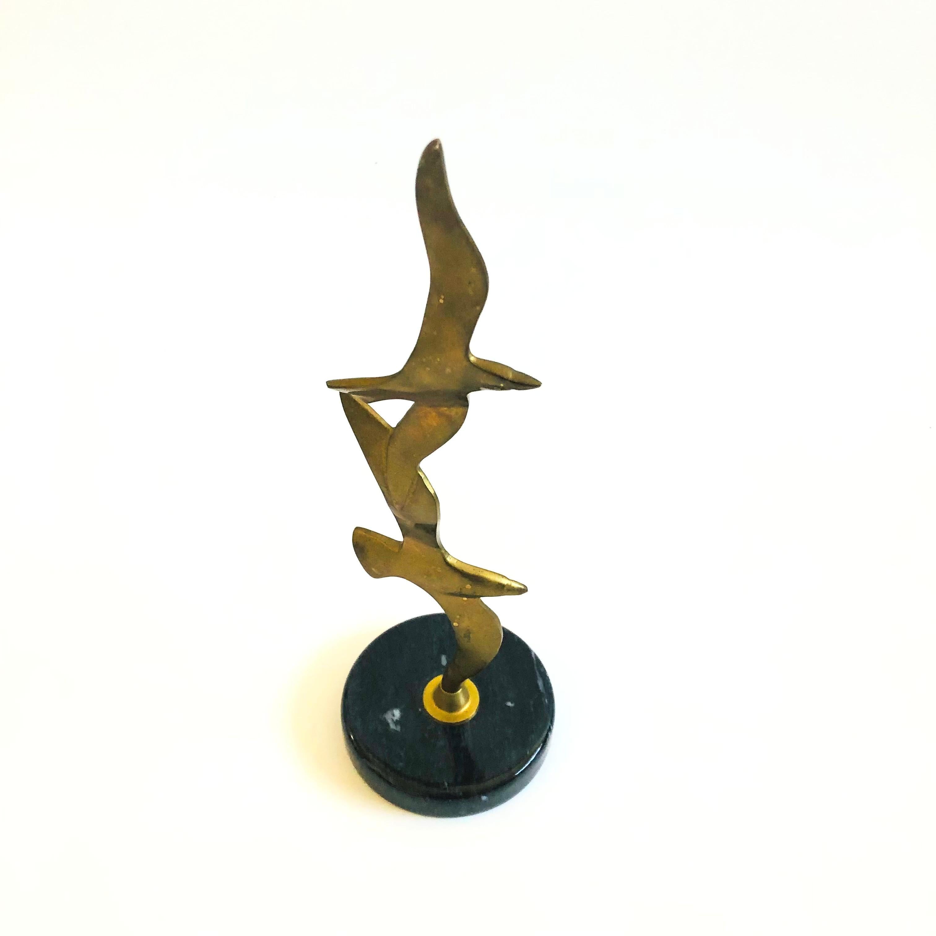 Un'alta scultura in ottone vintage di gabbiani impilati montata su una base circolare in marmo.

