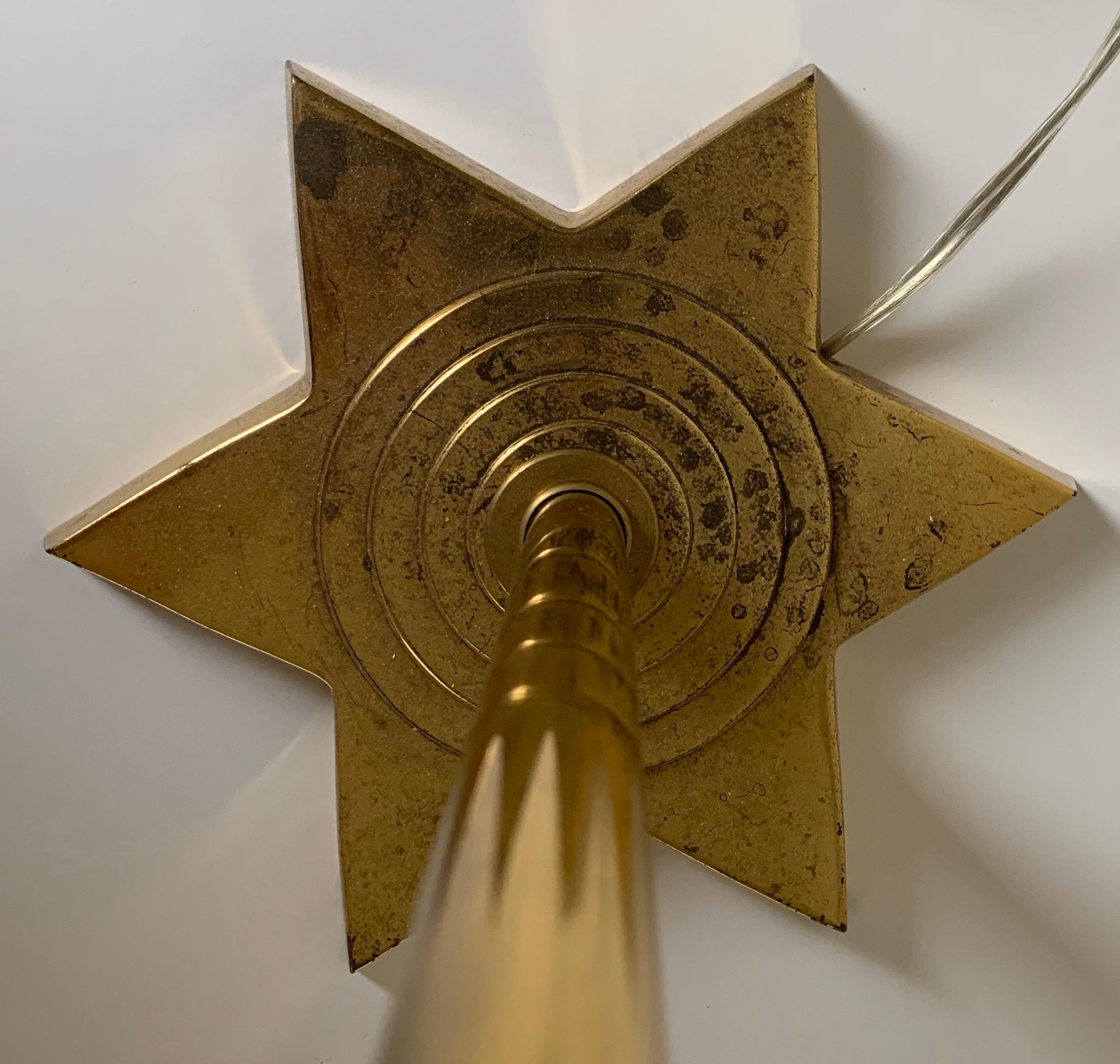 Tall solid brass floor lamp with star motif base. Newly rewired, lamp takes one standard bulb (not included). Includes harp/finial and pleated cream linen lampshade.