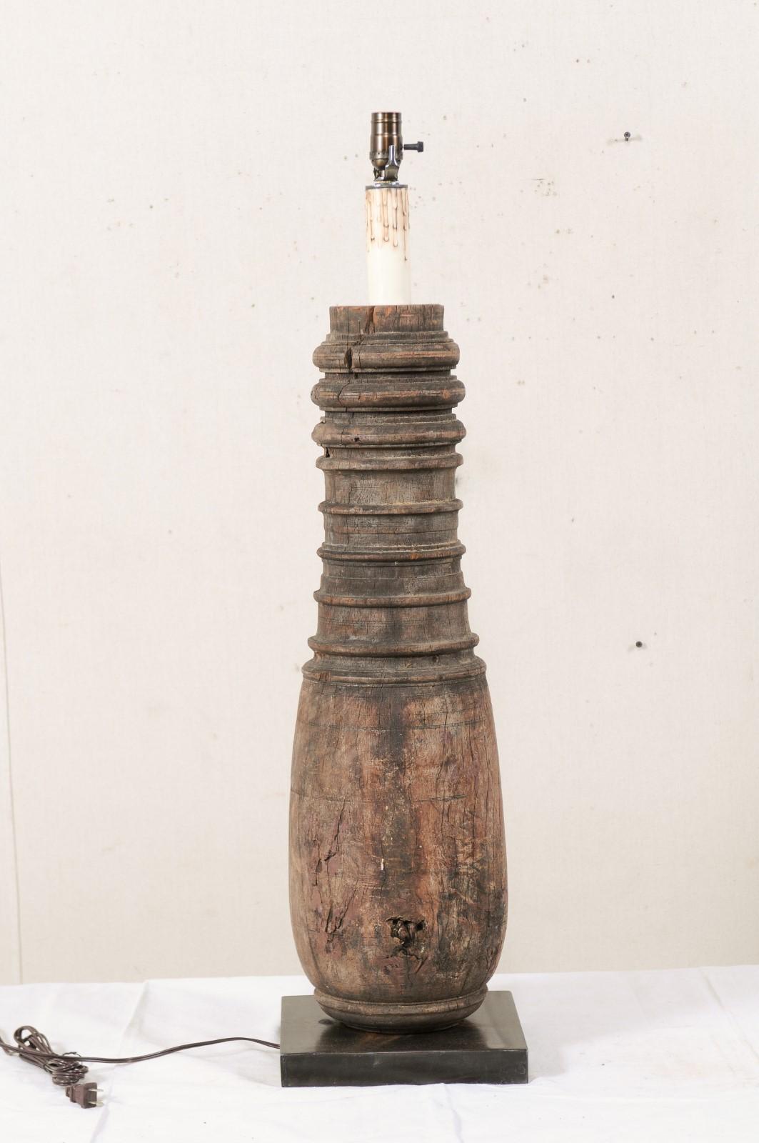 A tall single table lamp with a 19th century British Colonial Column body. This single table lamp has been custom fashioned from a cut section of a 19th century British Colonial carved wood column, which has been mounted on a square-shaped iron