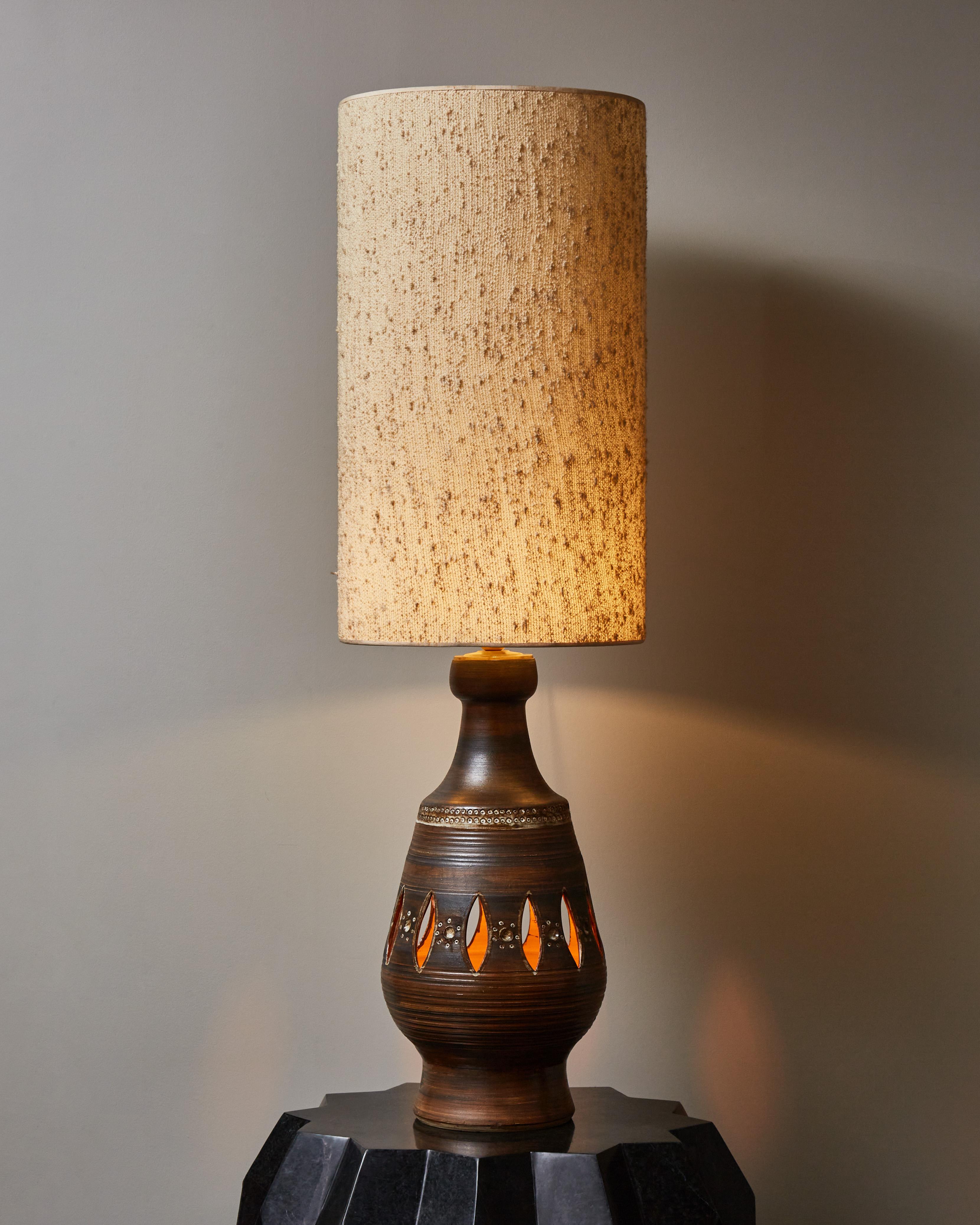 Imposing table lamp made in mat glazed ceramic with decors and openworks letting through the inner light.
