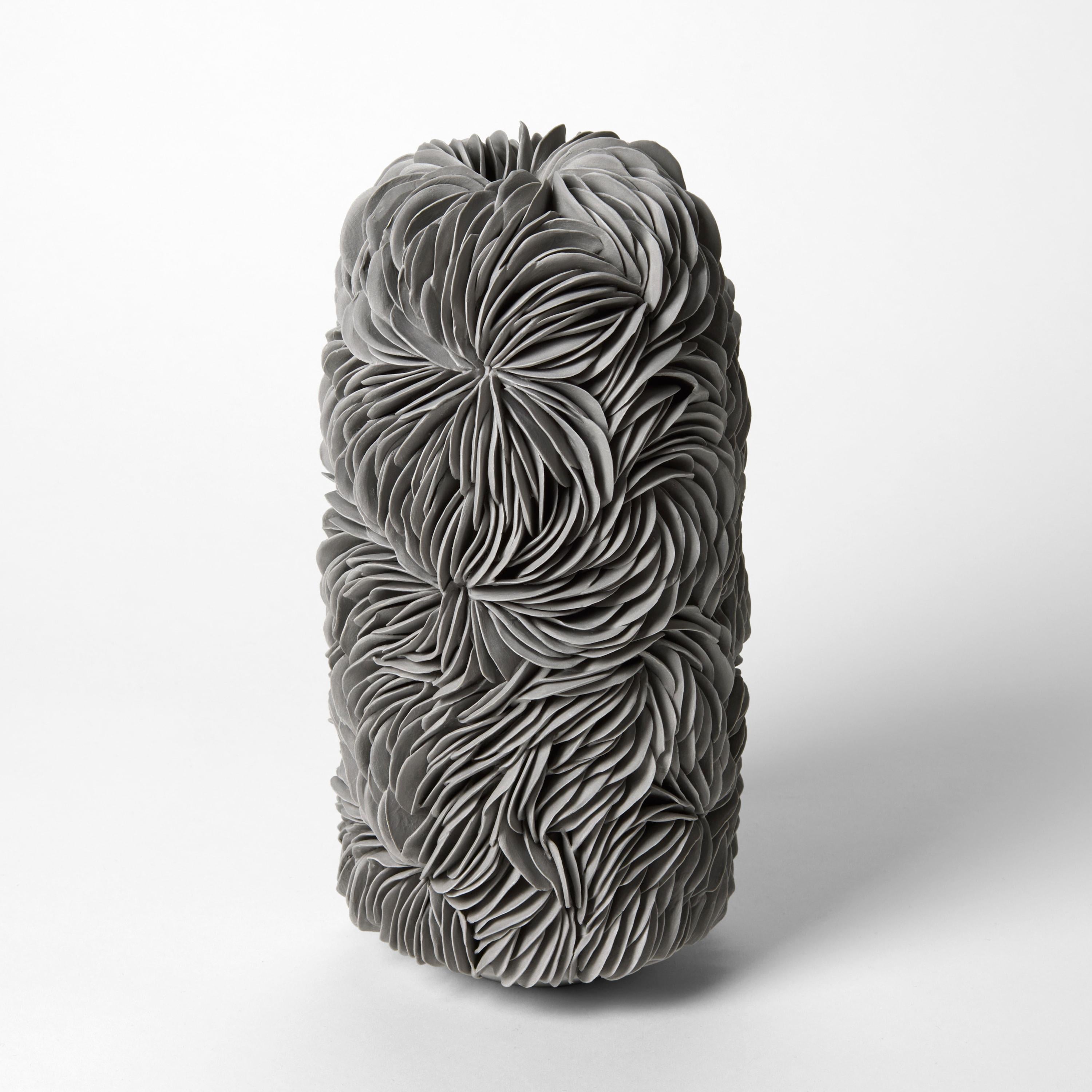 'Tall Budding Vessel in Grey' è una scultura in porcellana unica dell'artista britannica Olivia Walker.

Walker lavora con la porcellana per creare pezzi che esplorano le idee di crescita e decadenza attraverso la costruzione e la stratificazione di