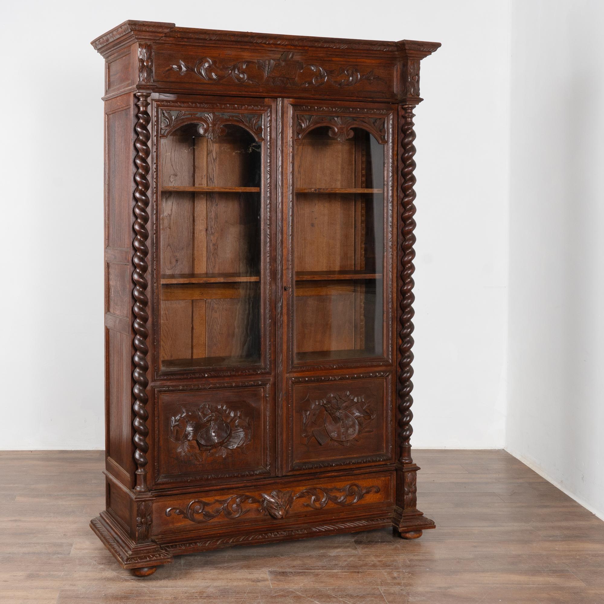 Impressionante libreria rinascimentale in Oak pesantemente intagliata con 2 ante in vetro e ripiani regolabili.
Le colonne a torsione d'orzo, le decorazioni intagliate lungo la corona, i cassetti, i pannelli e tutto il resto contribuiscono a rendere
