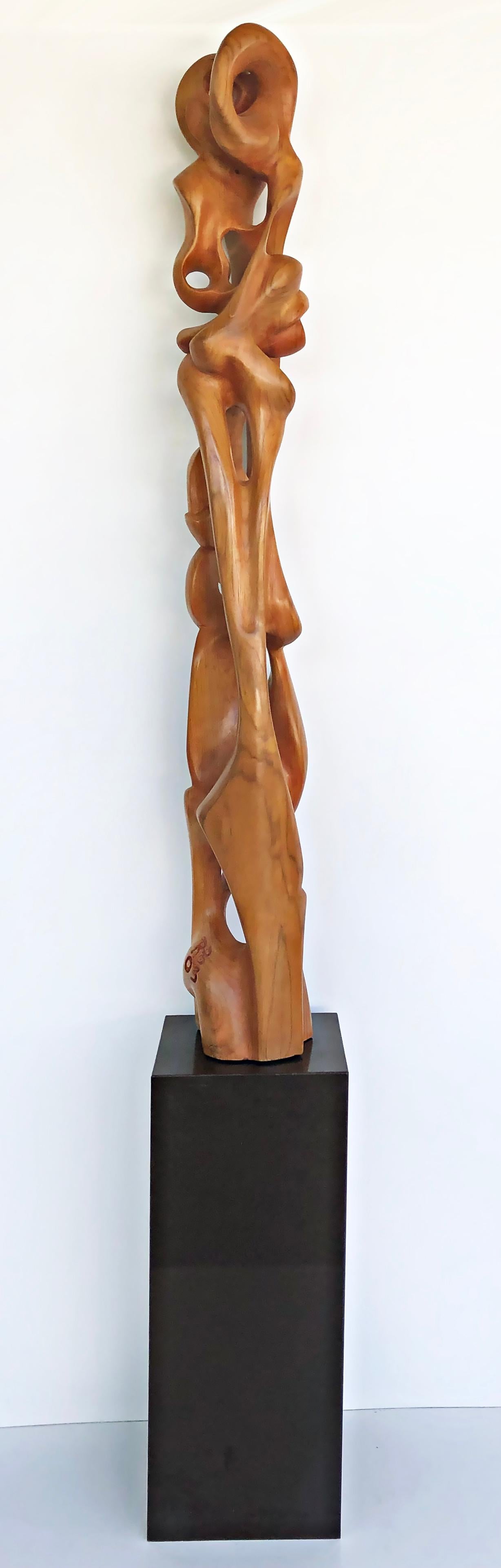 Tall carved teak sculpture by Ramon Barales, Cuban American Artist, 2003.

Offered for sale is monumental solid teak carved figurative sculpture by the Cuban American artist Ramon Barales (b 1974, Cuba). The very tall sculpture is presented upon a