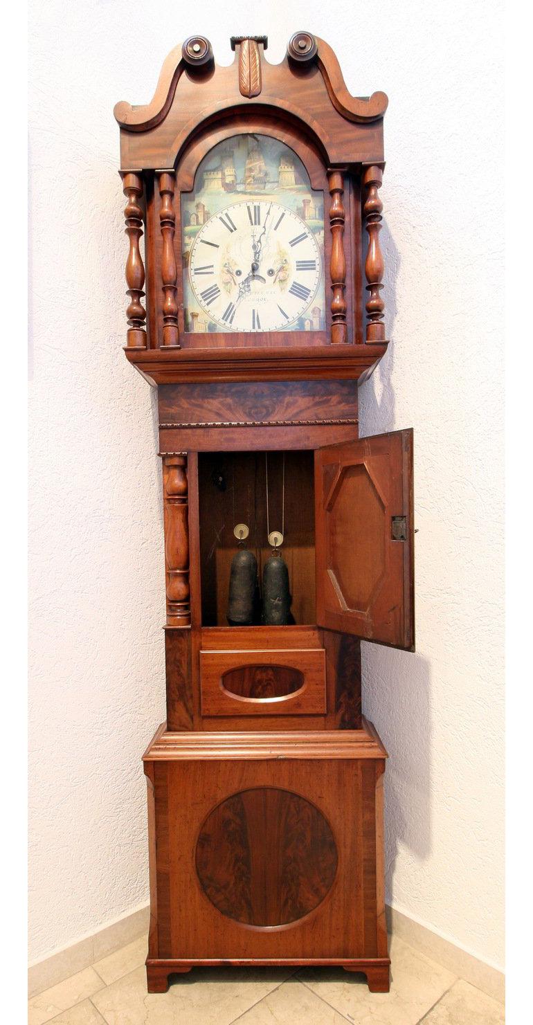 Das Gehäuse der Standuhr ist aus Mahagoni und wurde möglicherweise von dem Uhrmacher Nathaniel Edgecombe gefertigt. Die Uhr stammt aus Bristol, England, um 1830.
+ Das Schiff im Zifferblatt bewegt sich und spiegelt den zweiten Balken
+ Datums- und