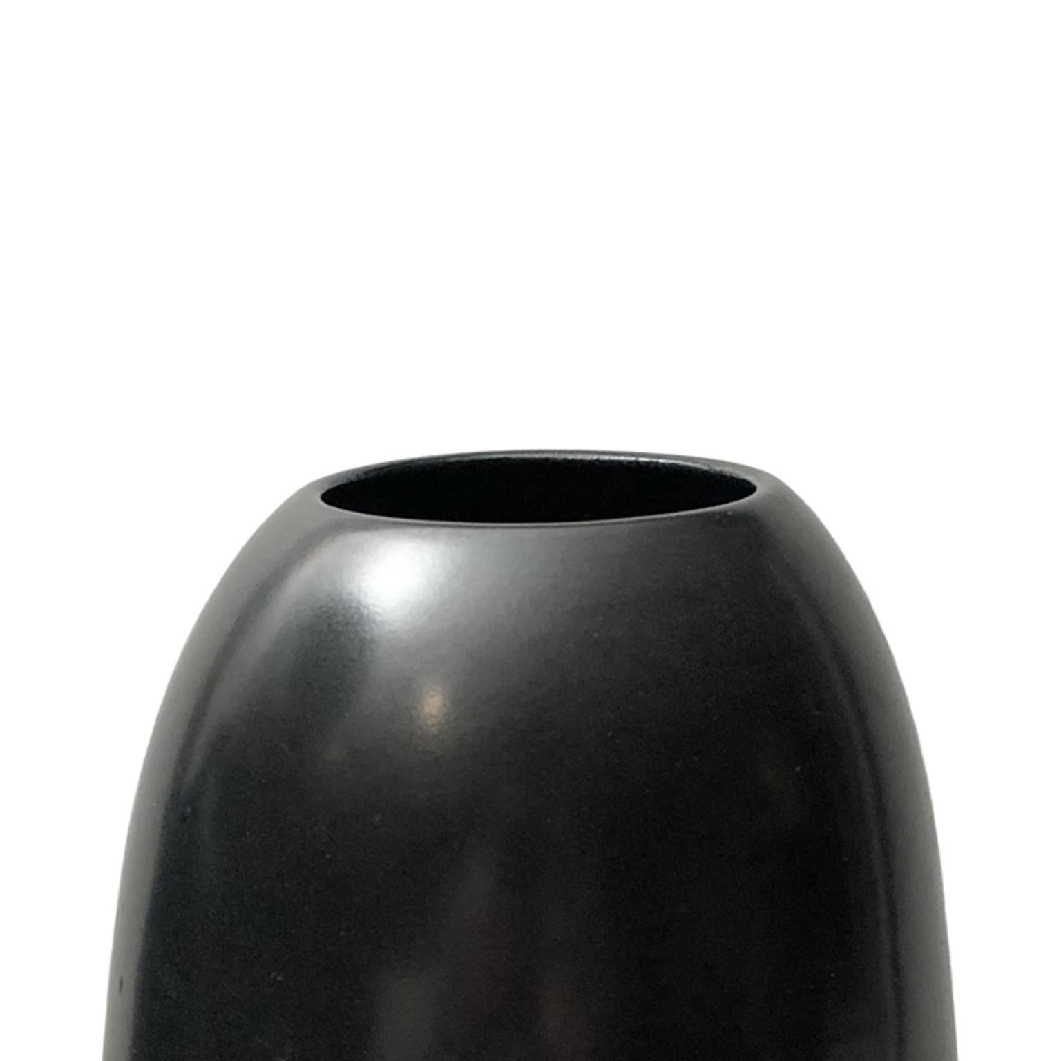 Tall ceramic pointed base ripple vase with black lustre glaze by Sandi Fellman, 2018. 

Veteran photographer Sandi Fellman's ceramic vessels are an exploration of a new medium. The forms, palettes, and sensuality of her photos can be found within
