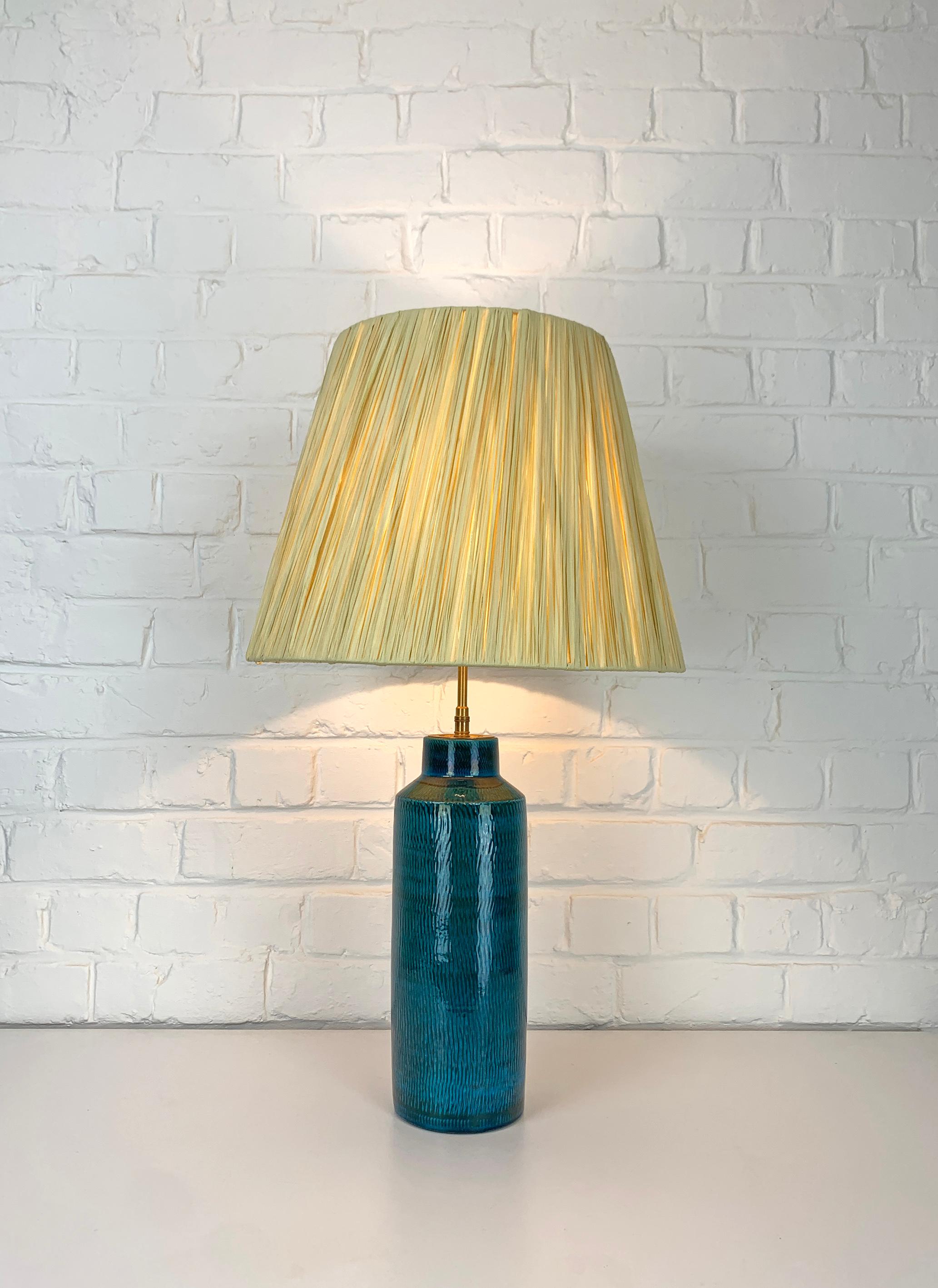 Grande lampada da tavolo scandinava in gres di Nymølle Pottery, Danimarca. Smaltato nei toni del blu/turchese.
Nuovo paralume in rafia fatto a mano su una struttura di paralume vintage.

Prodotto da Nymølle Pottery, Danimarca, probabilmente negli