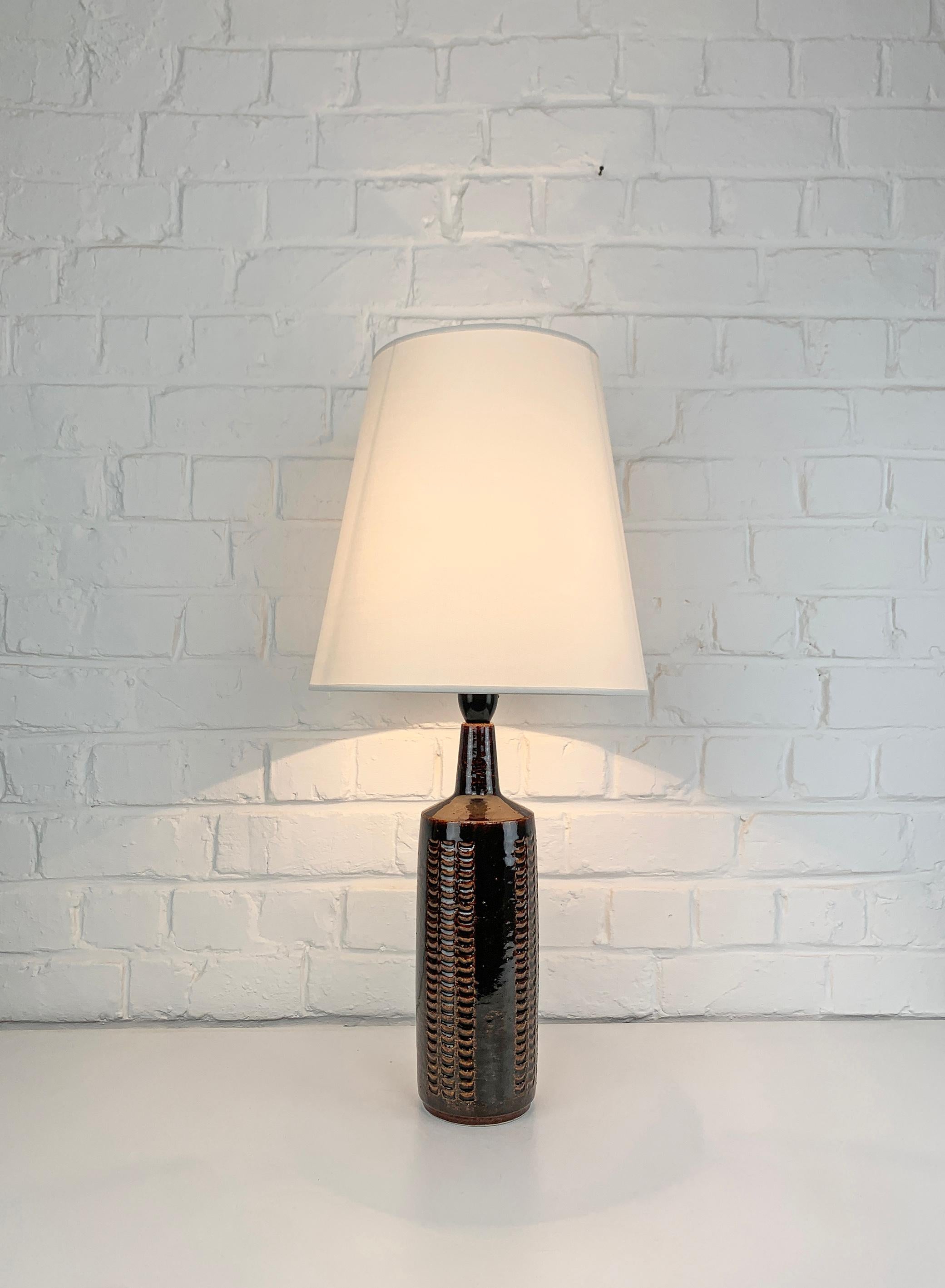 Cette lampe a été produite par Palshus (Danemark), fondée par Per et sa femme Annelise Linnemann-Schmidt. 

Le couple a créé et produit des objets en chamotte (argile danoise) avec des décorations imprimées (vaisselle, vases et lampes). Leur design