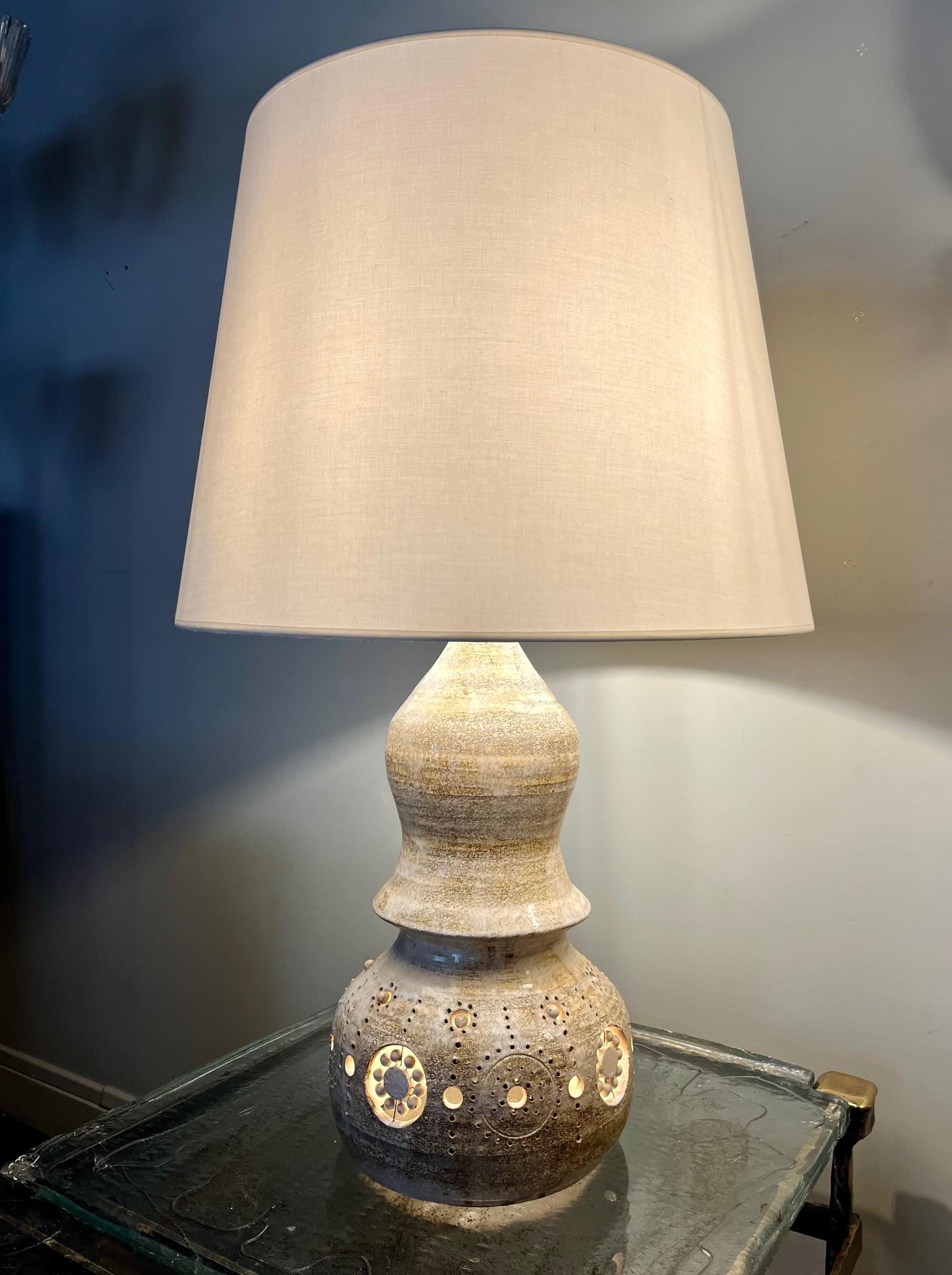 Lampe de table en céramique émaillée. 
Ajouré sur tout le corps de la lampe.
La céramique est émaillée dans des tons crème ou beige. 
Double électrification avec lumière à l'intérieur du corps de la lampe 
Recâblé. 
 Cannes, sud de la France, vers