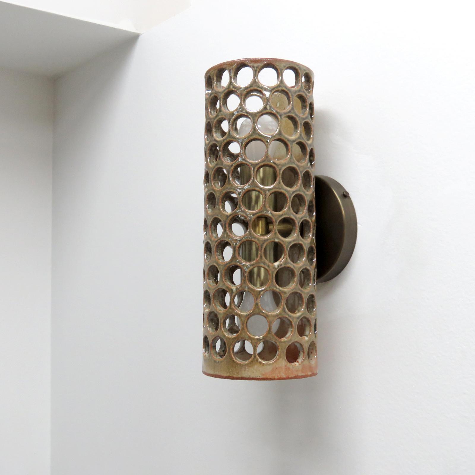 Stunning tall cylindrical ceramic wall light No.52, designed and handcrafted by Los Angeles based ceramicist Heather Levine. High fired stoneware with olive/salmon colored gradient glaze body with decorative perforations to expose light in patterns
