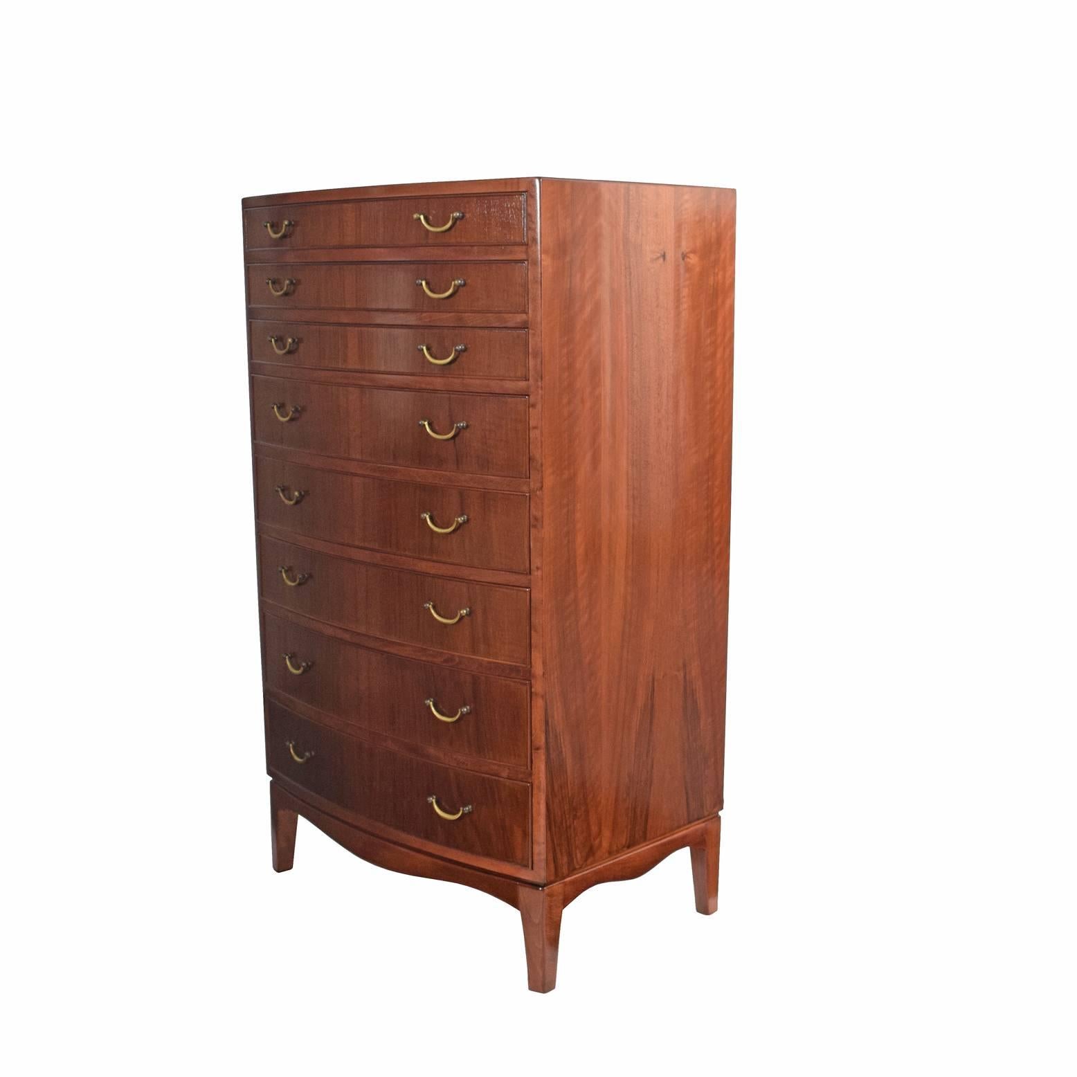 Tall chest of drawers with eight walnut drawers, brass pulls and curved front on each drawer with profile edge.