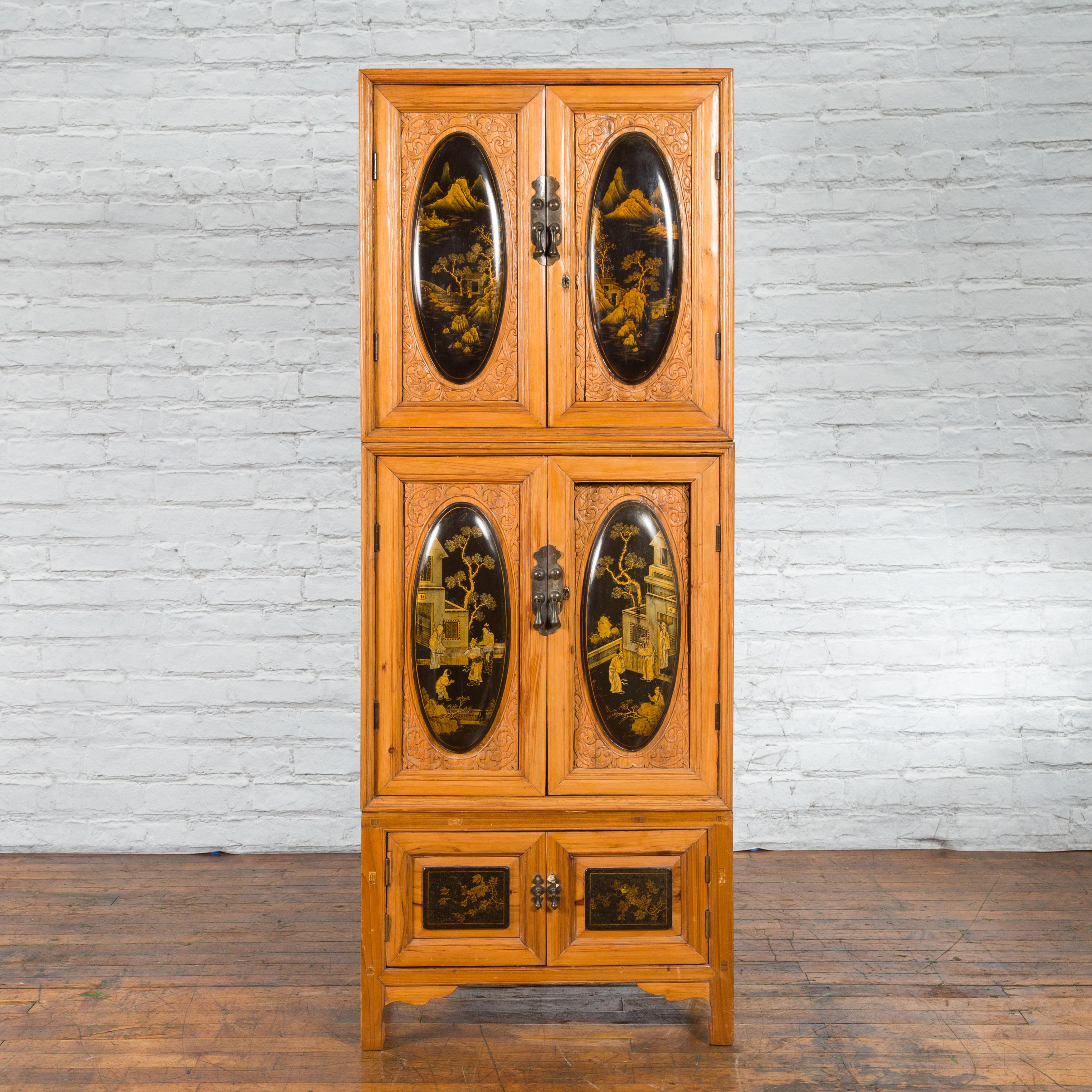 A tall Chinese Qing Dynasty style wooden cabinet from the late 20th century, with chinoiserie panels. Created in China, this cabinet is made of natural wood with beautifully carved and lacquered chinoiserie panels. Organized into three sections of