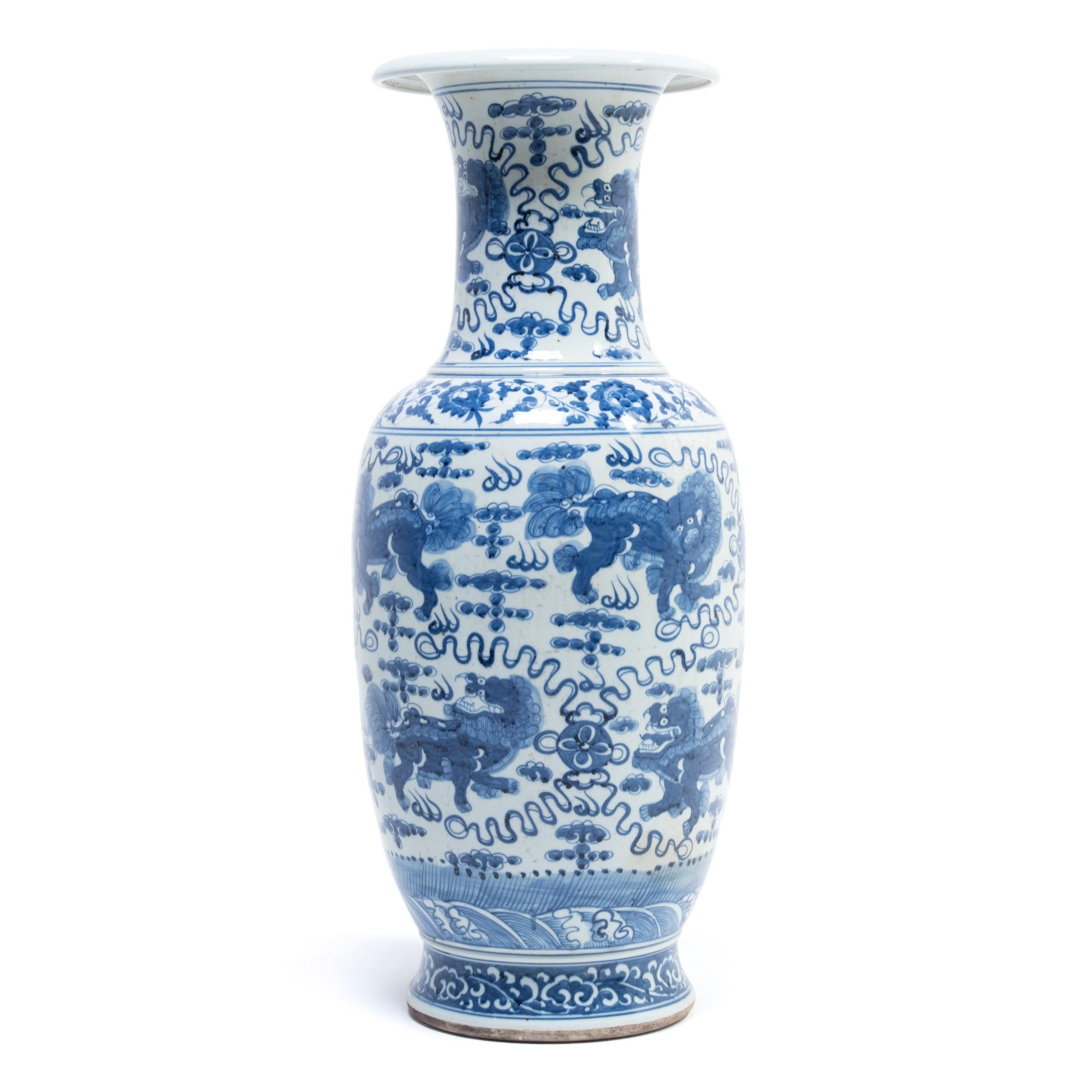 A parade of Qilin, Chinese mythical creatures symbolizing magnificence, joy and benevolence, march around this hand painted porcelain fantail vase. It is a wonderful example of contemporary Chinese blue and white porcelain that has been sought by