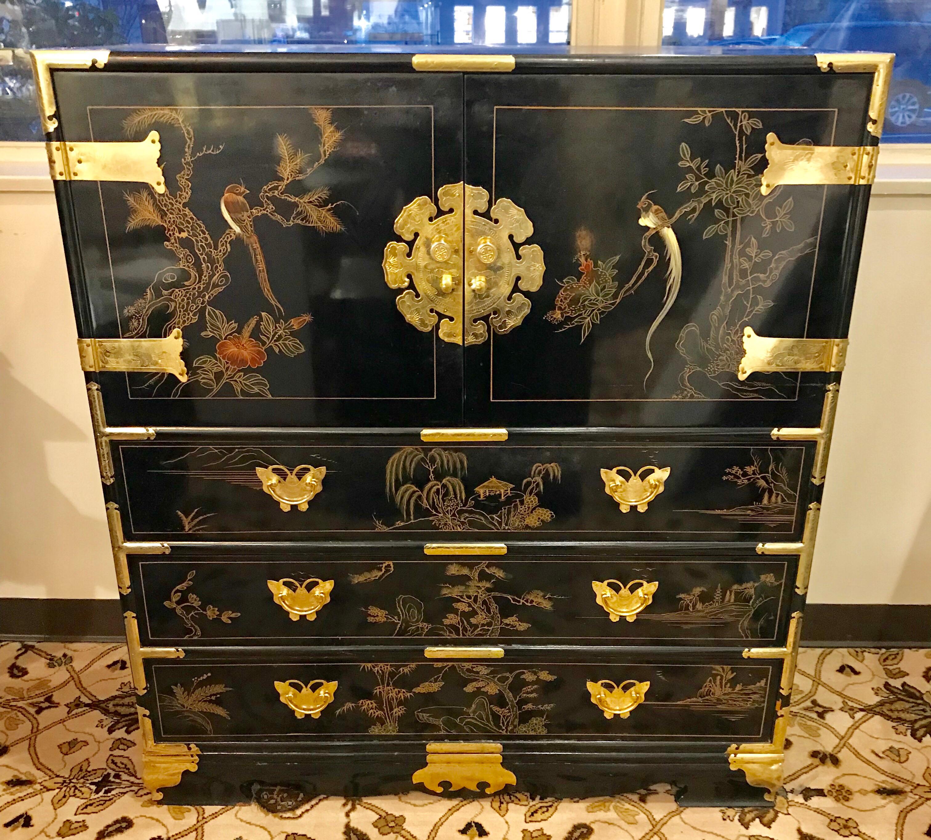 Black lacquer chinoiserie tall chest with hand painted flowers and birds has plenty of storage in its bottom three drawers while top doors open to storage compartment and three smaller drawers  Features ornate incised brass hardware and butterfly