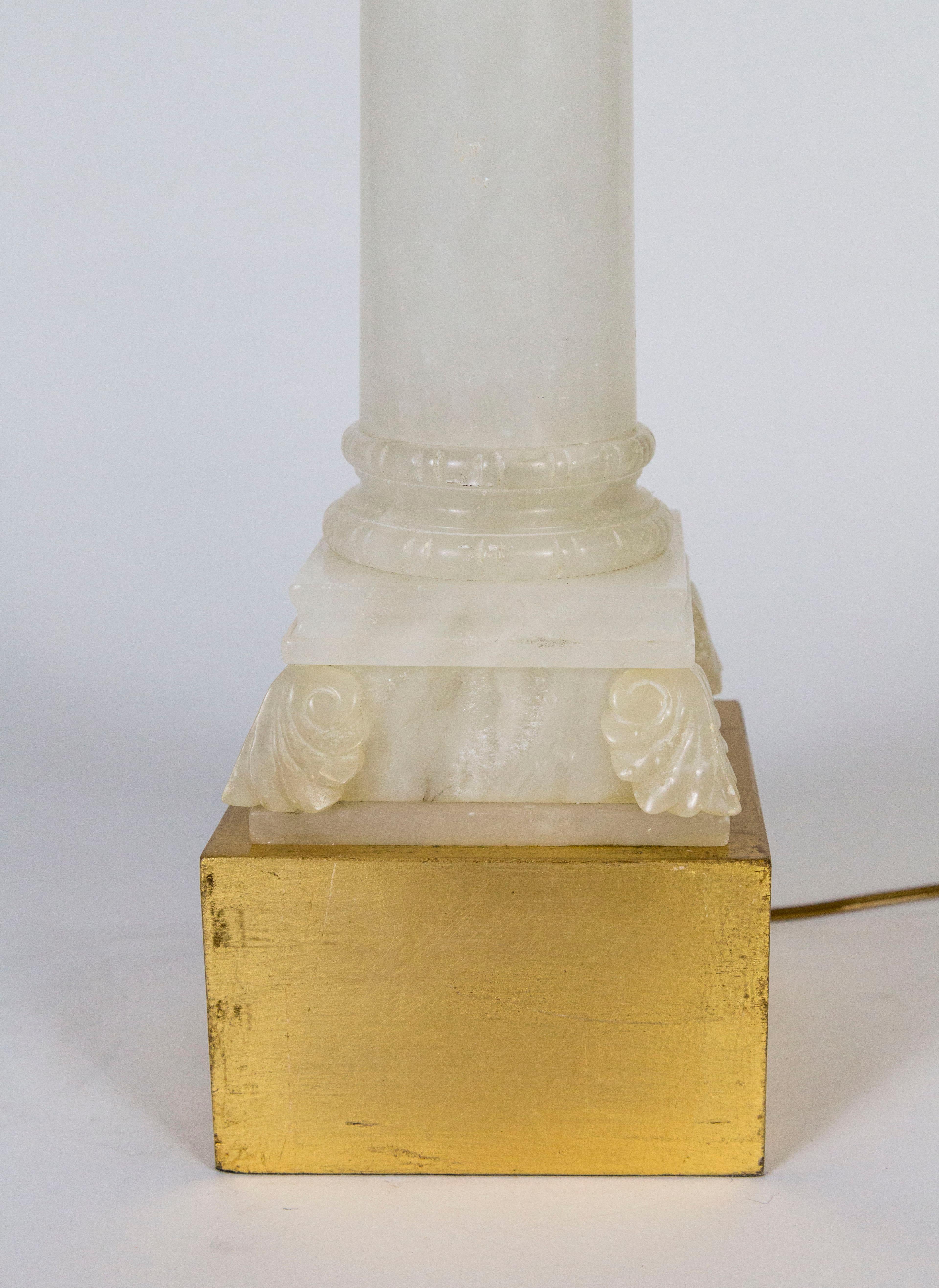 A gorgeous, polished, alabaster lamp in the form of a column with an acanthus leaf adorned capital. With an elevated, square, gilt base and neck. Measures: 30” height x 6” x 6.25.”.